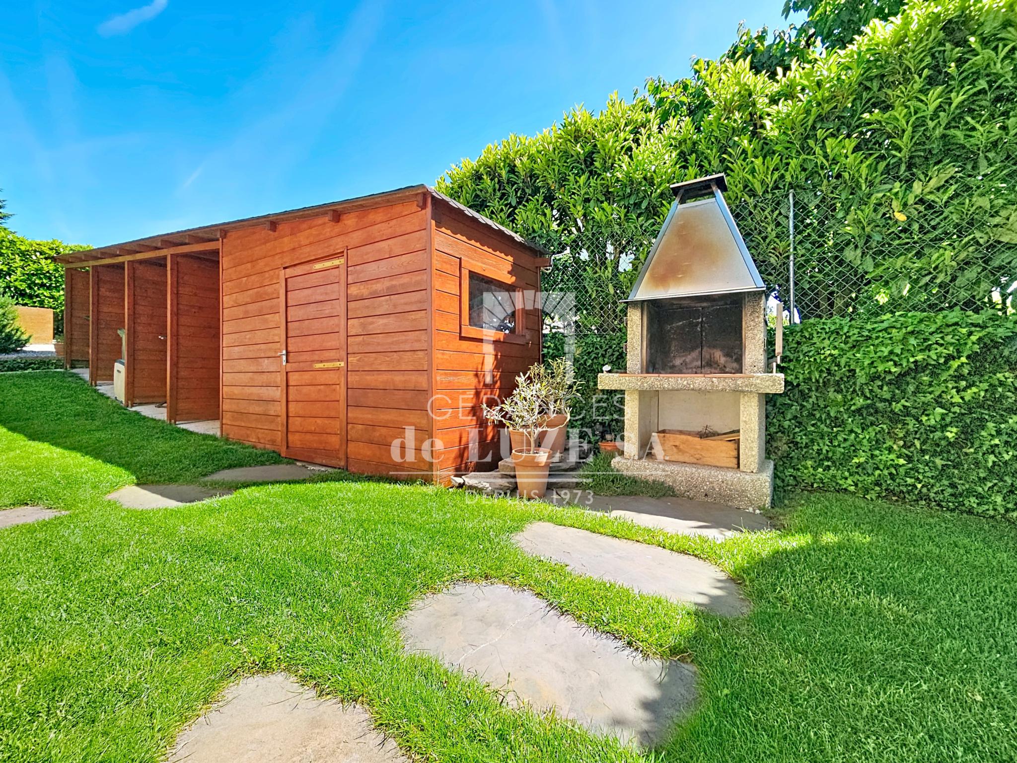 Garten mit Holzschuppen und Außengrill