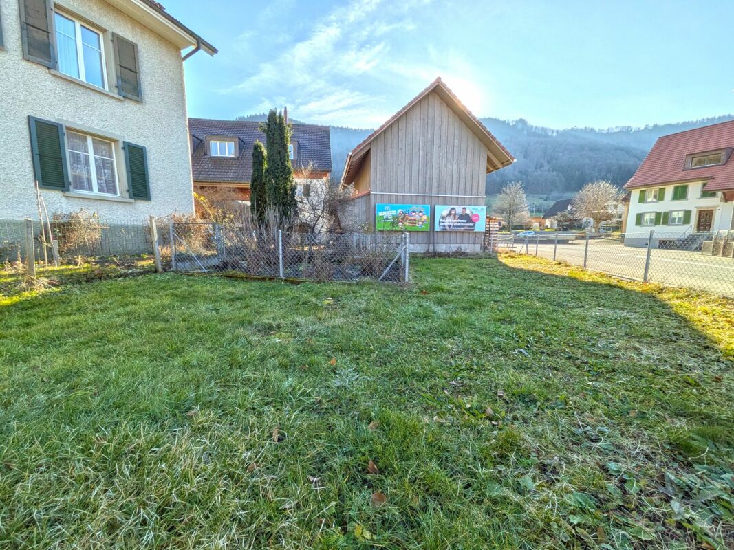 Grundstück mit Wiese und Nachbarhäusern