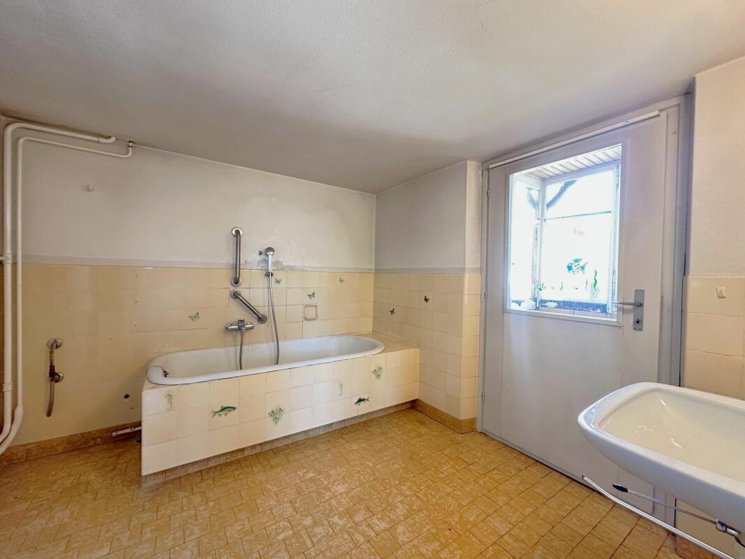 Badezimmer mit Badewanne und Türfenster