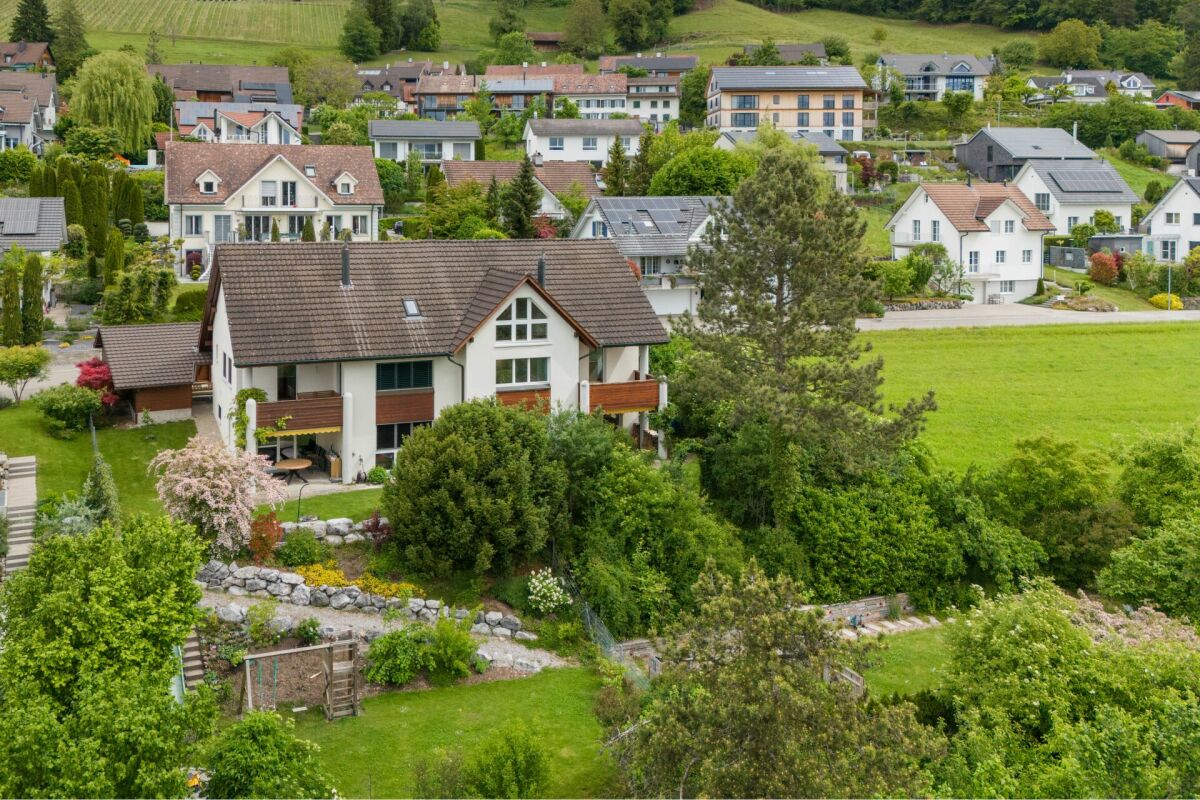Luftaufnahme eines Einfamilienhauses in grüner Hügellage