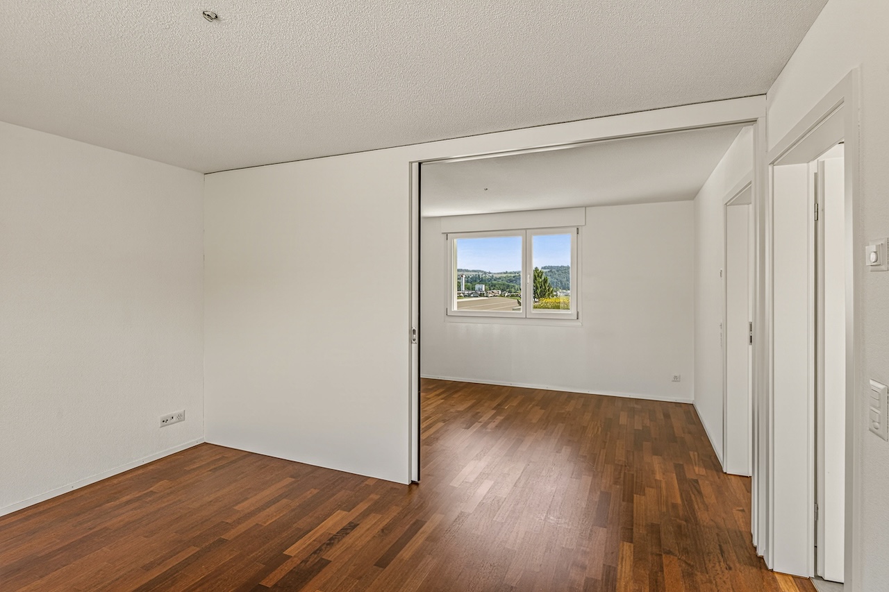 Leerer heller Raum mit Holzfußboden und Schiebetür