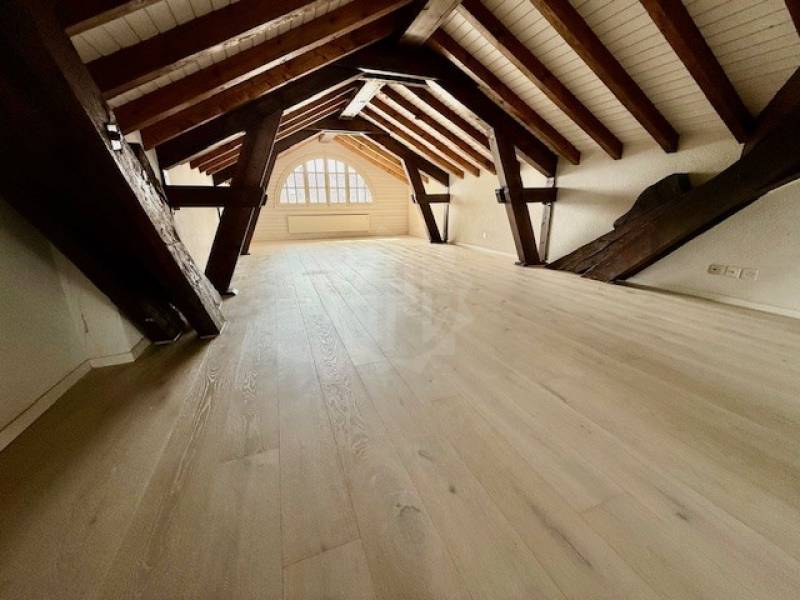 Dachgeschossraum mit sichtbaren Holzbalken