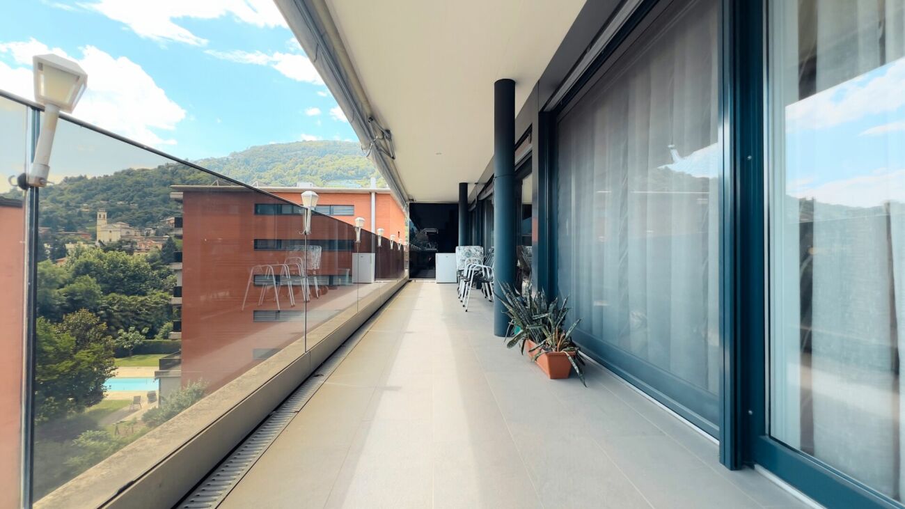 Langer Balkon mit Glasgeländer und Bergblick