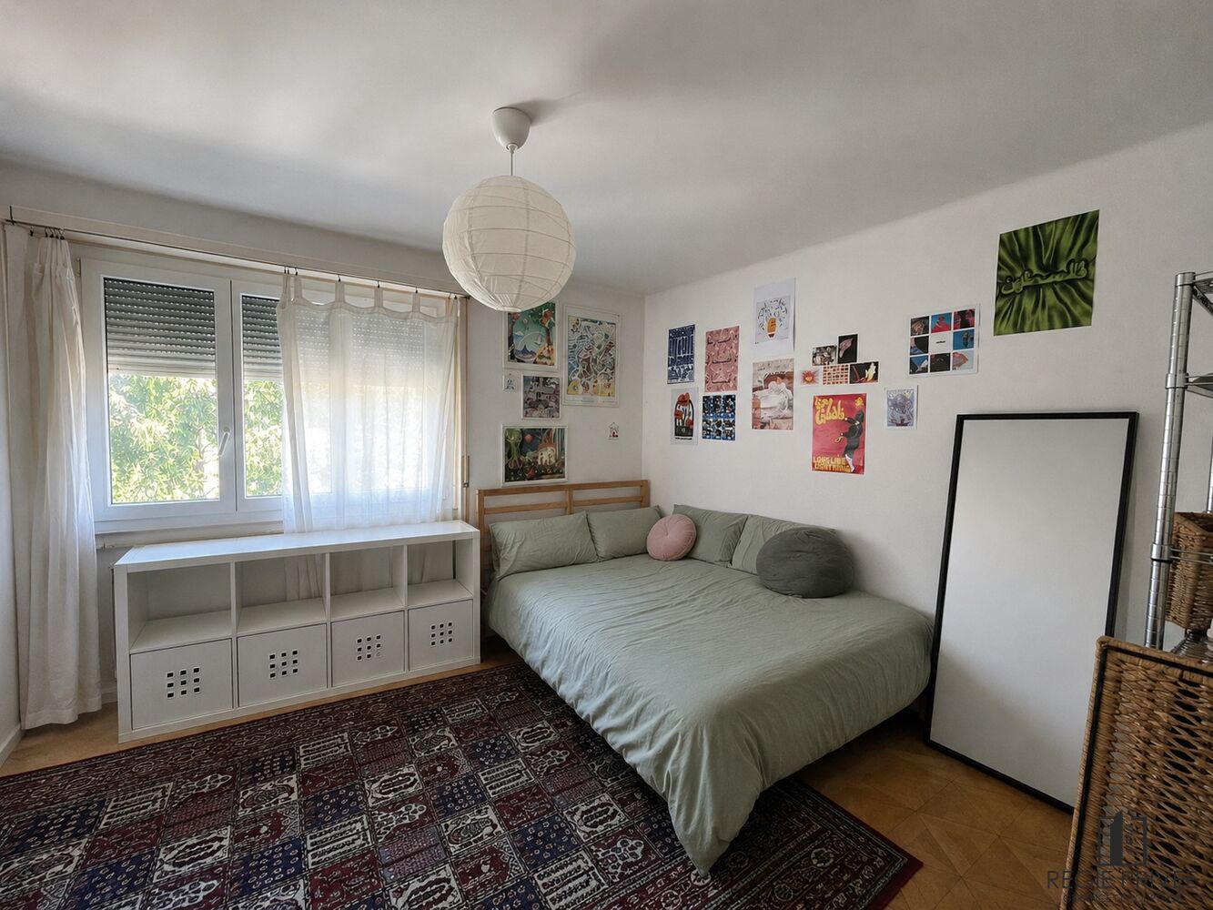 Helles Schlafzimmer mit Fenster, Bett und Wanddeko