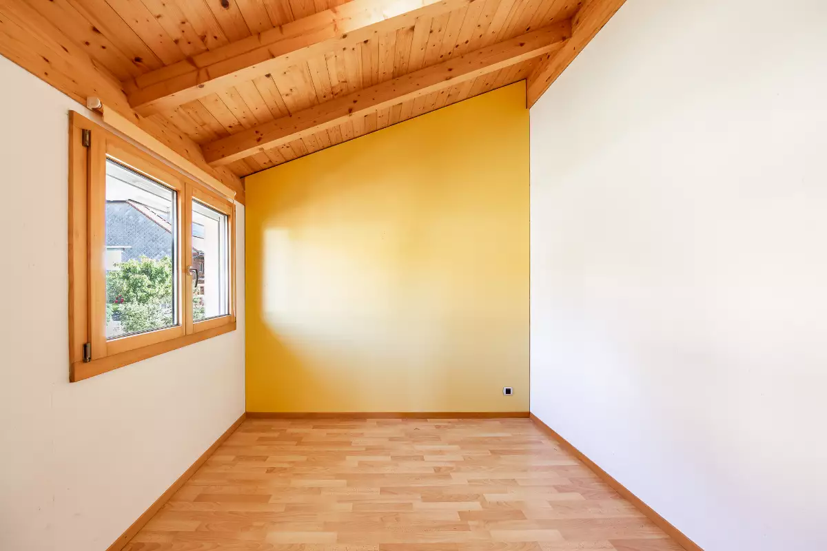 Heller leerer Raum mit Holzdecke und Fenster