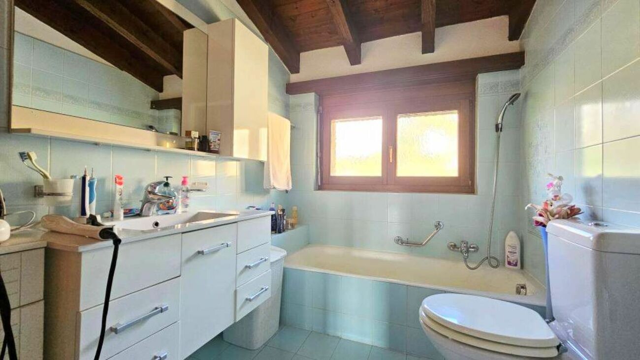Badezimmer mit Badewanne und Holzdecke