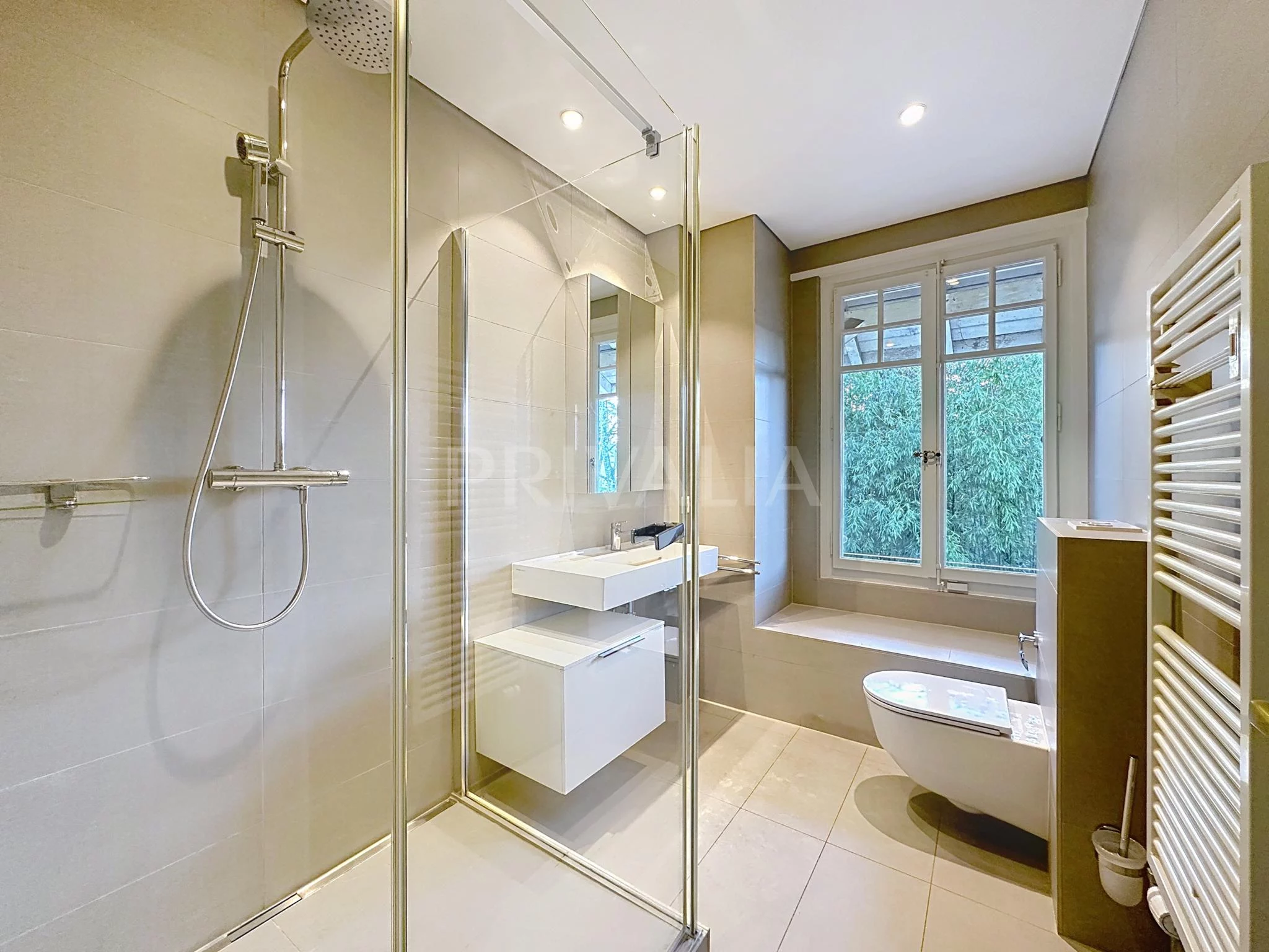 Modernes Badezimmer mit Glasdusche und Fensterbank