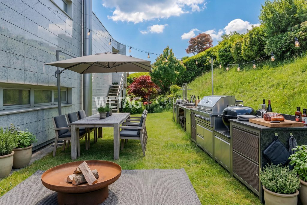Moderner Gartenbereich mit Outdoor-Küche und Essplatz