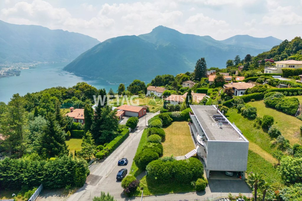 Luftaufnahme eines Hauses am Hang mit Seeblick