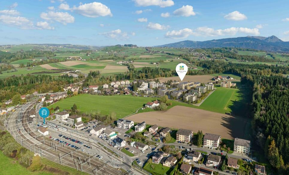 Luftaufnahme einer ländlichen Siedlung mit Bahntrasse