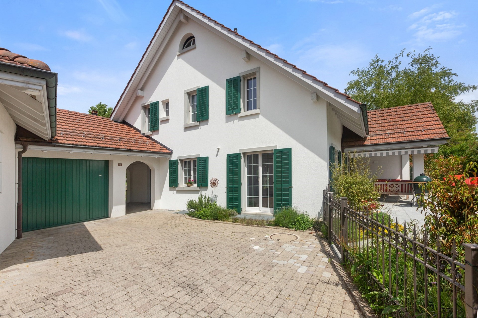 Außenansicht eines Einfamilienhauses mit Einfahrt und Garten