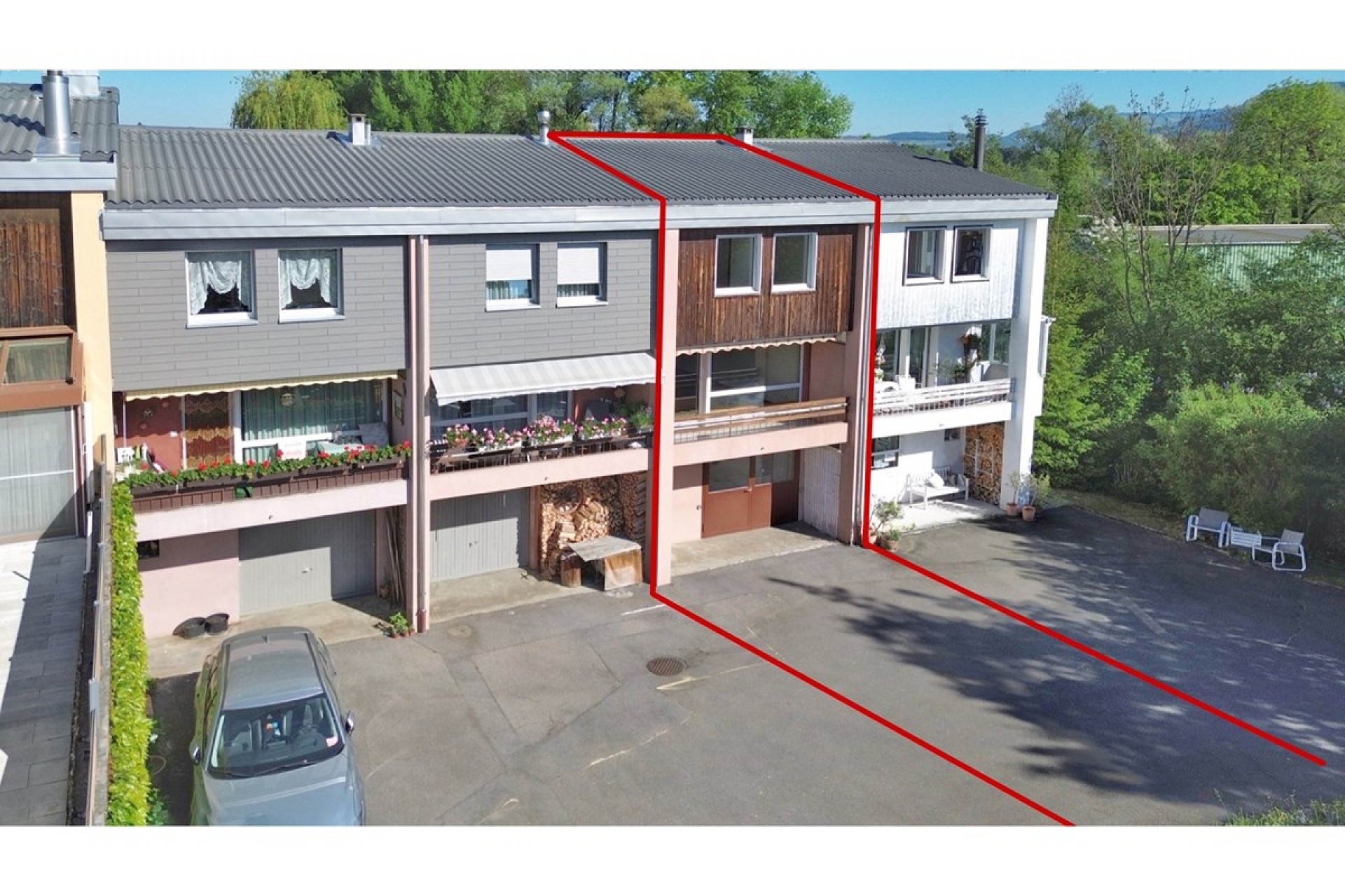 Mehrfamilienhaus mit markierter Wohneinheit und Garagenzufahrt