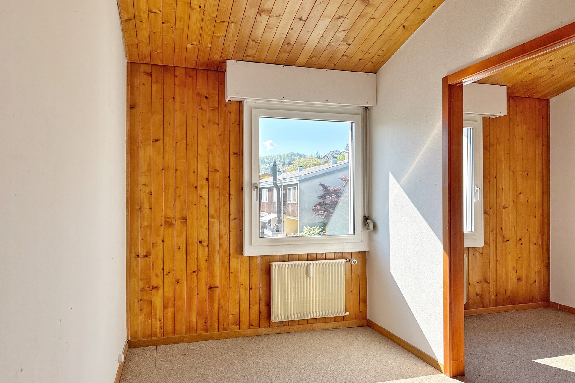 Helles Zimmer mit Holzverkleidung und Fenster