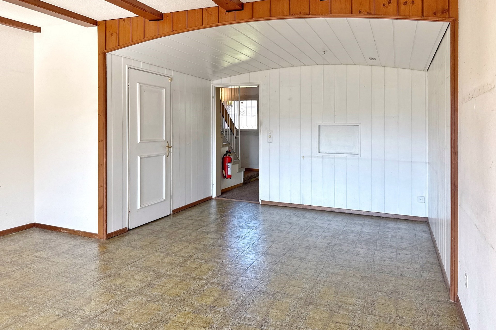 Leerer Innenraum mit Fliesenboden und Holzverkleidung