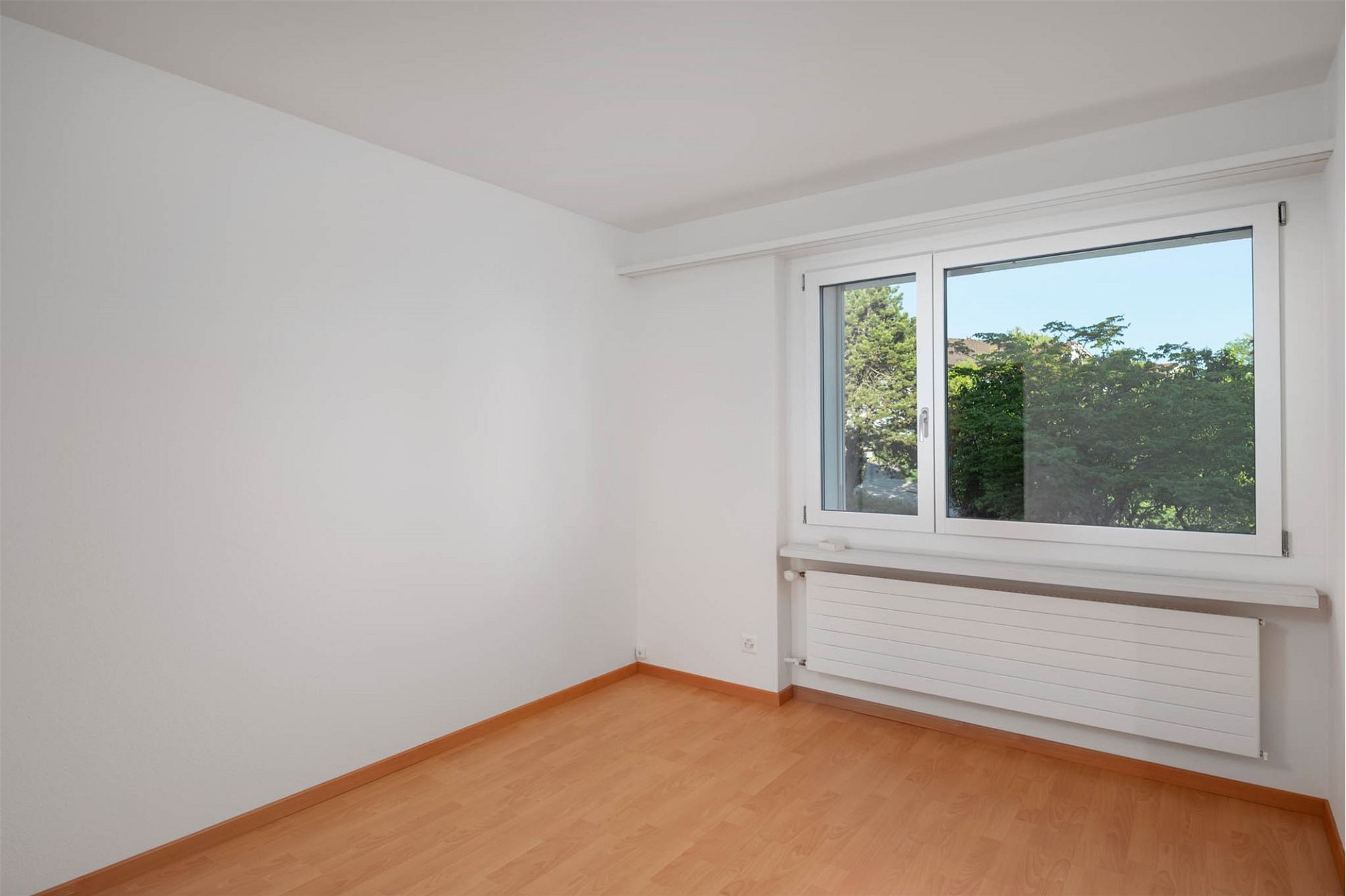 Helles leeres Zimmer mit Fenster und Heizkörper