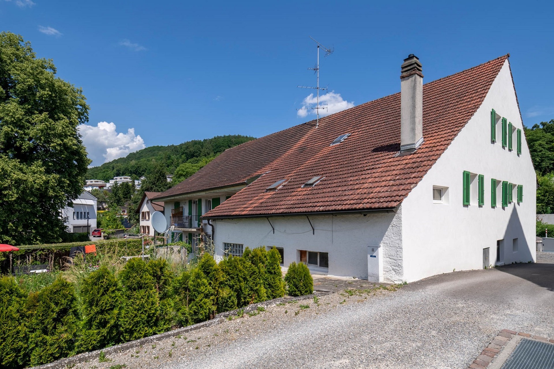 Einfamilienhaus mit Satteldach und grünen Fensterläden