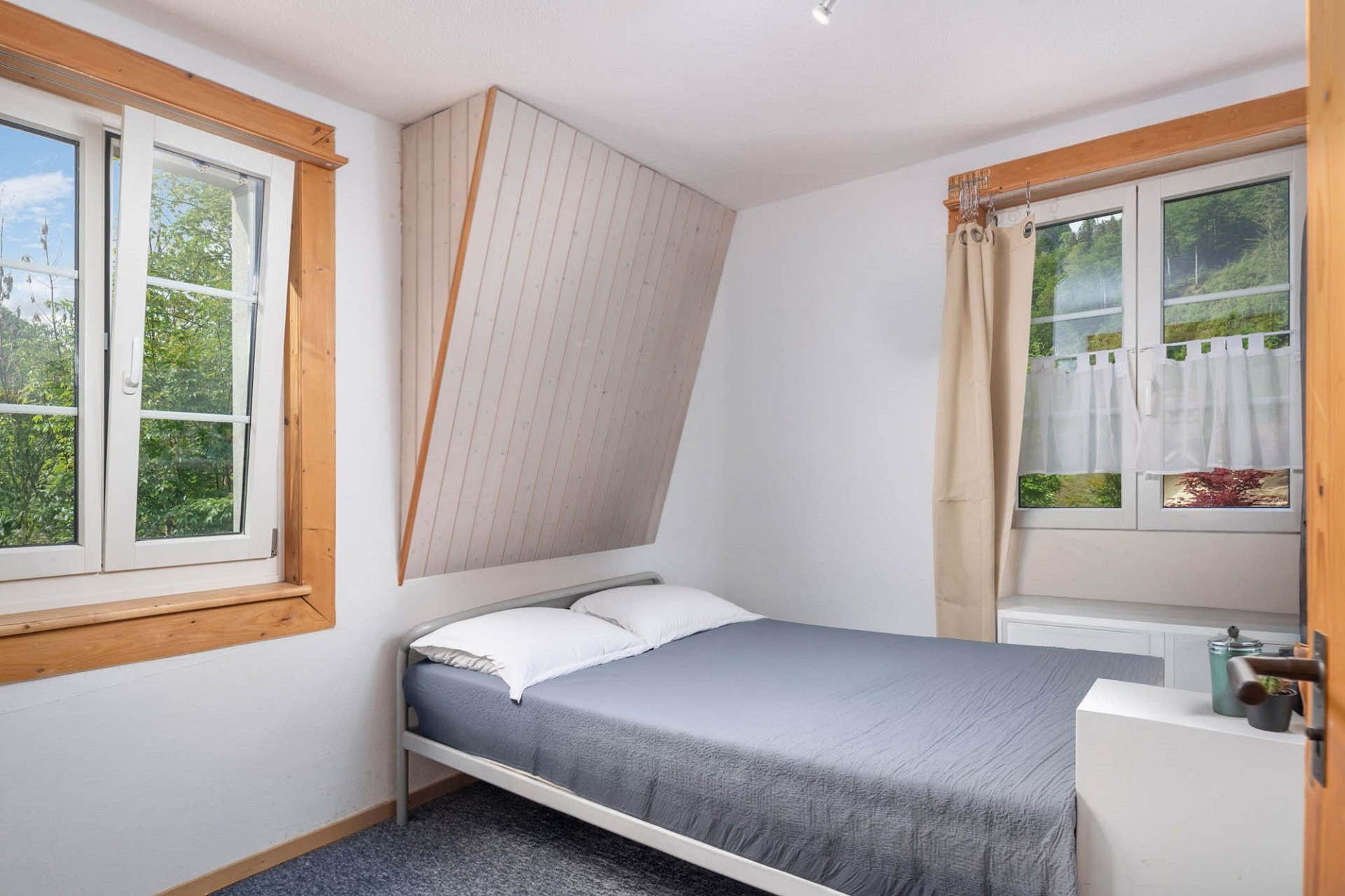 Kleines Schlafzimmer mit zwei Fenstern