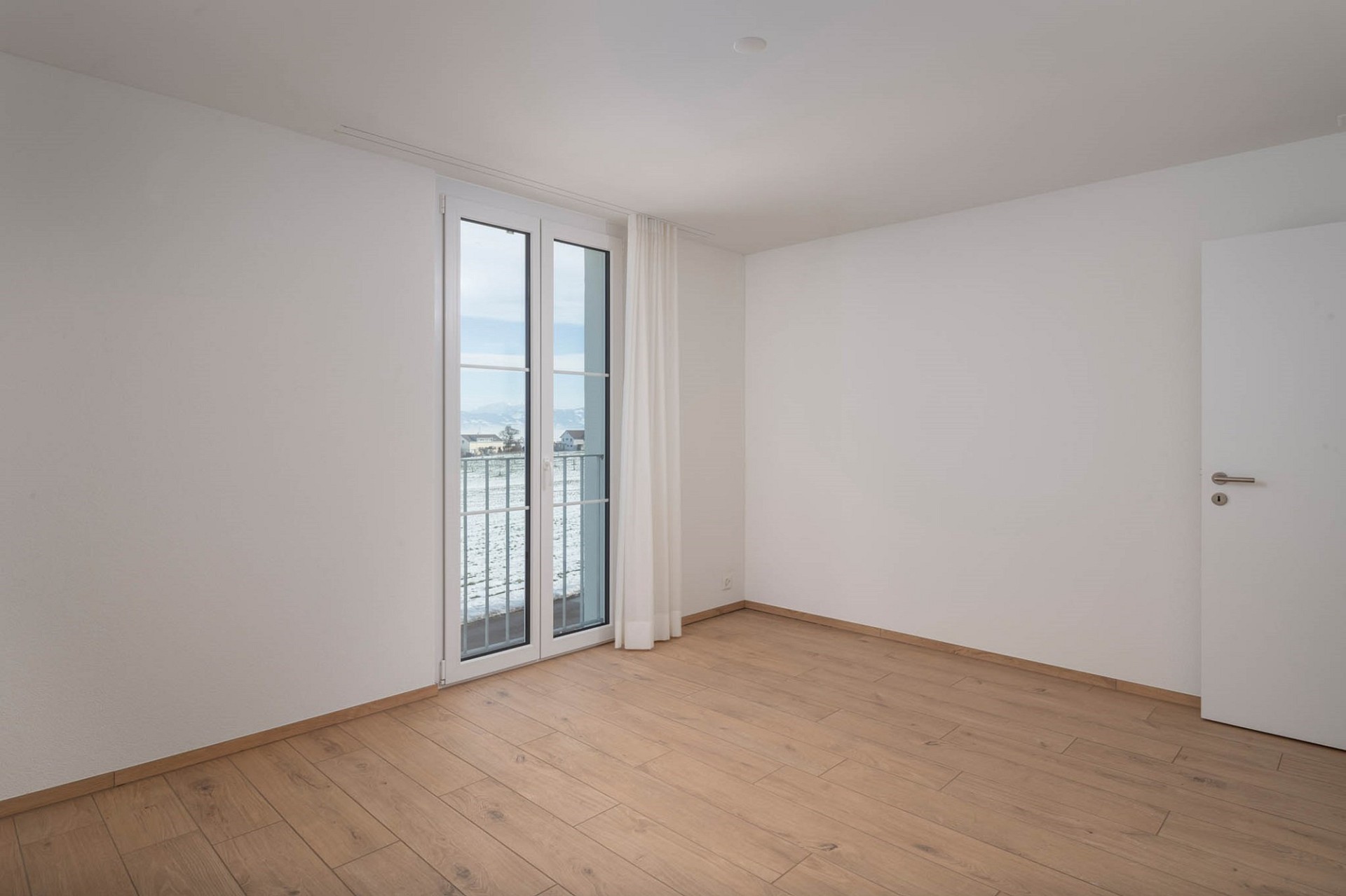 Heller leerer Raum mit Balkon- oder Terrassentür