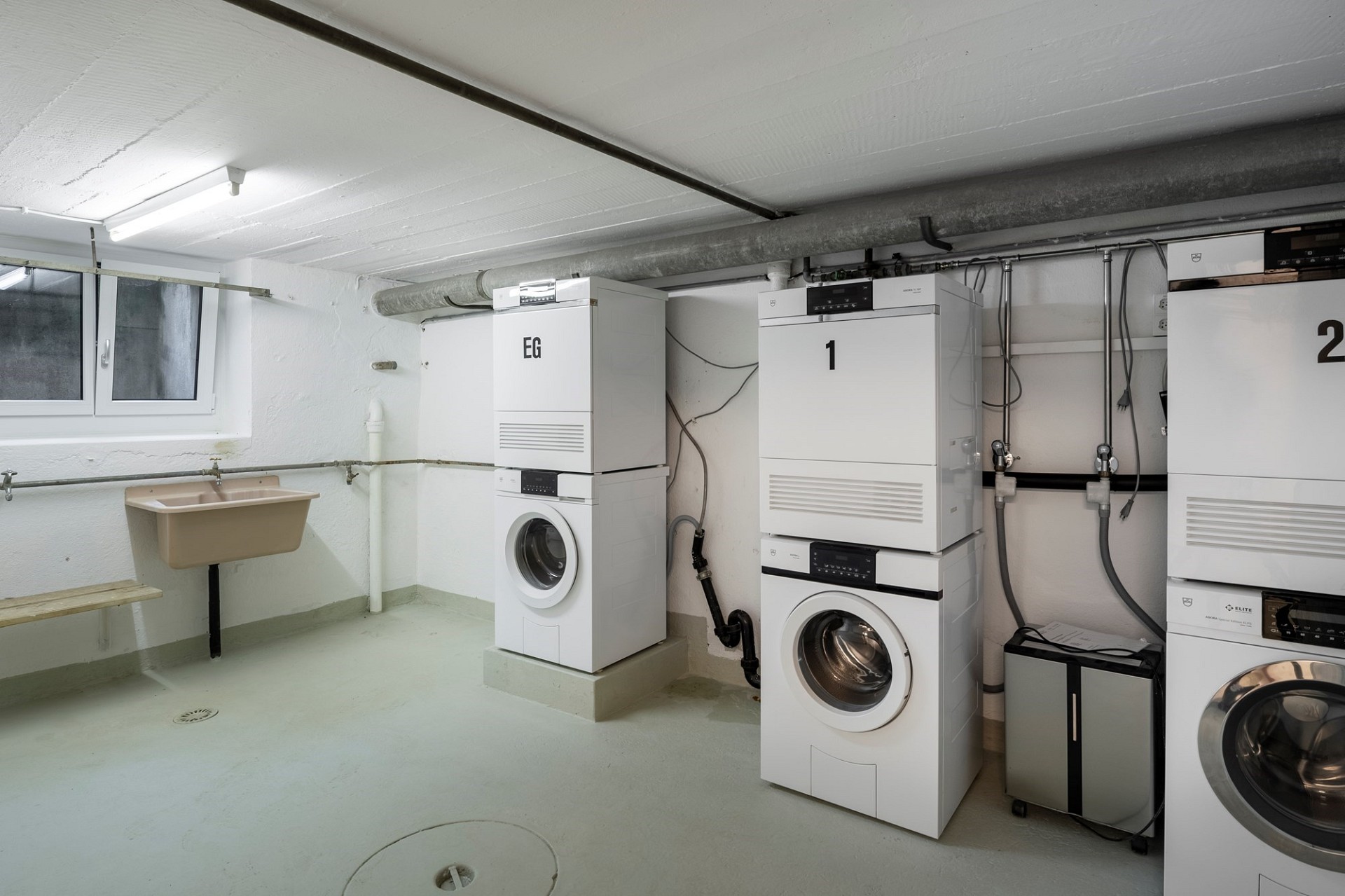 Technikraum im Keller mit Waschmaschinen und Wärmepumpen