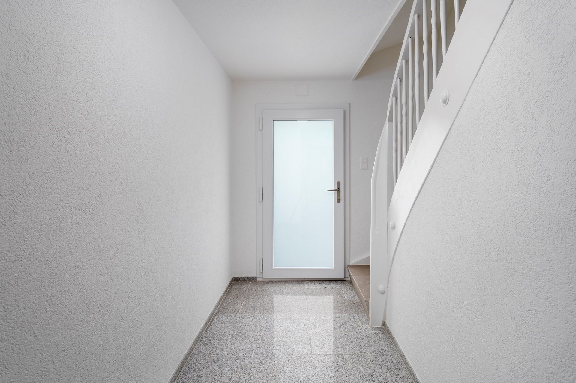 Heller Treppenflur mit Glastür