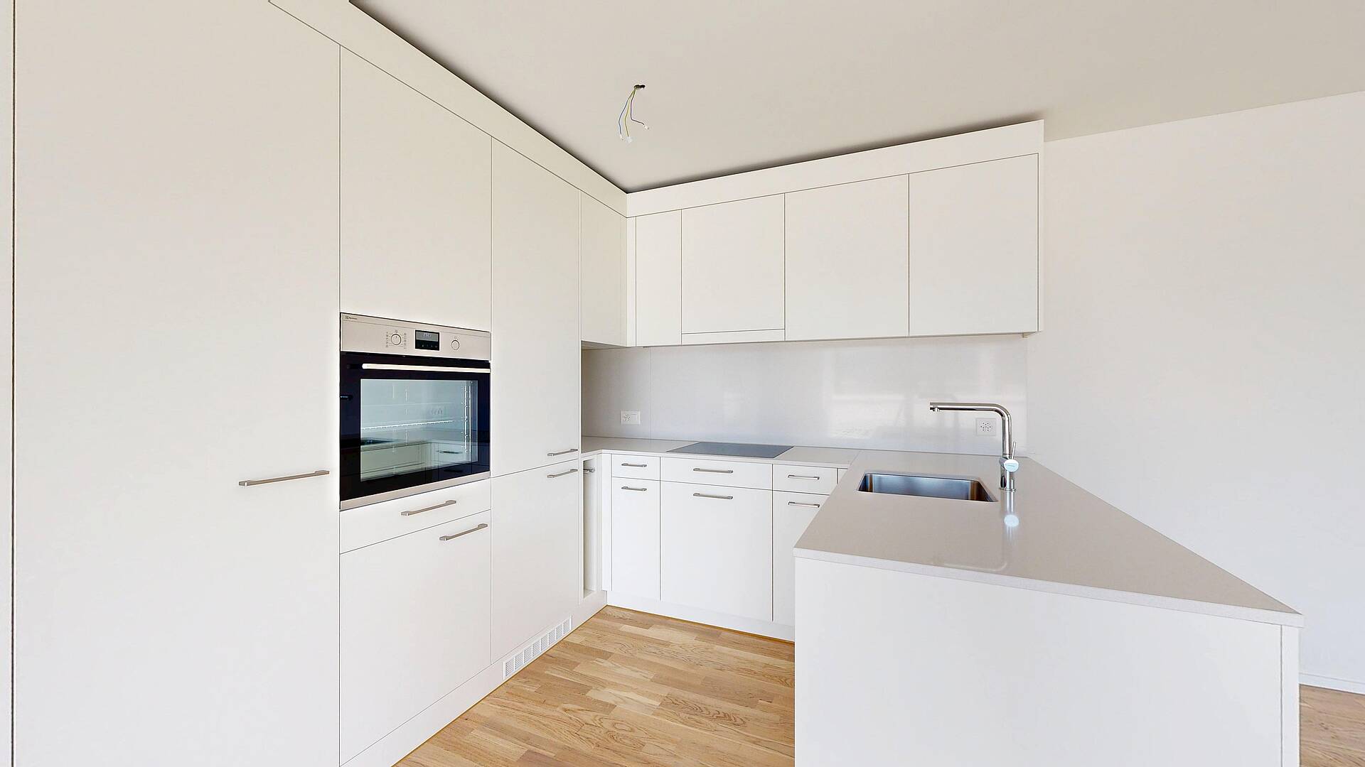 Moderne weiße Einbauküche mit Holzfußboden