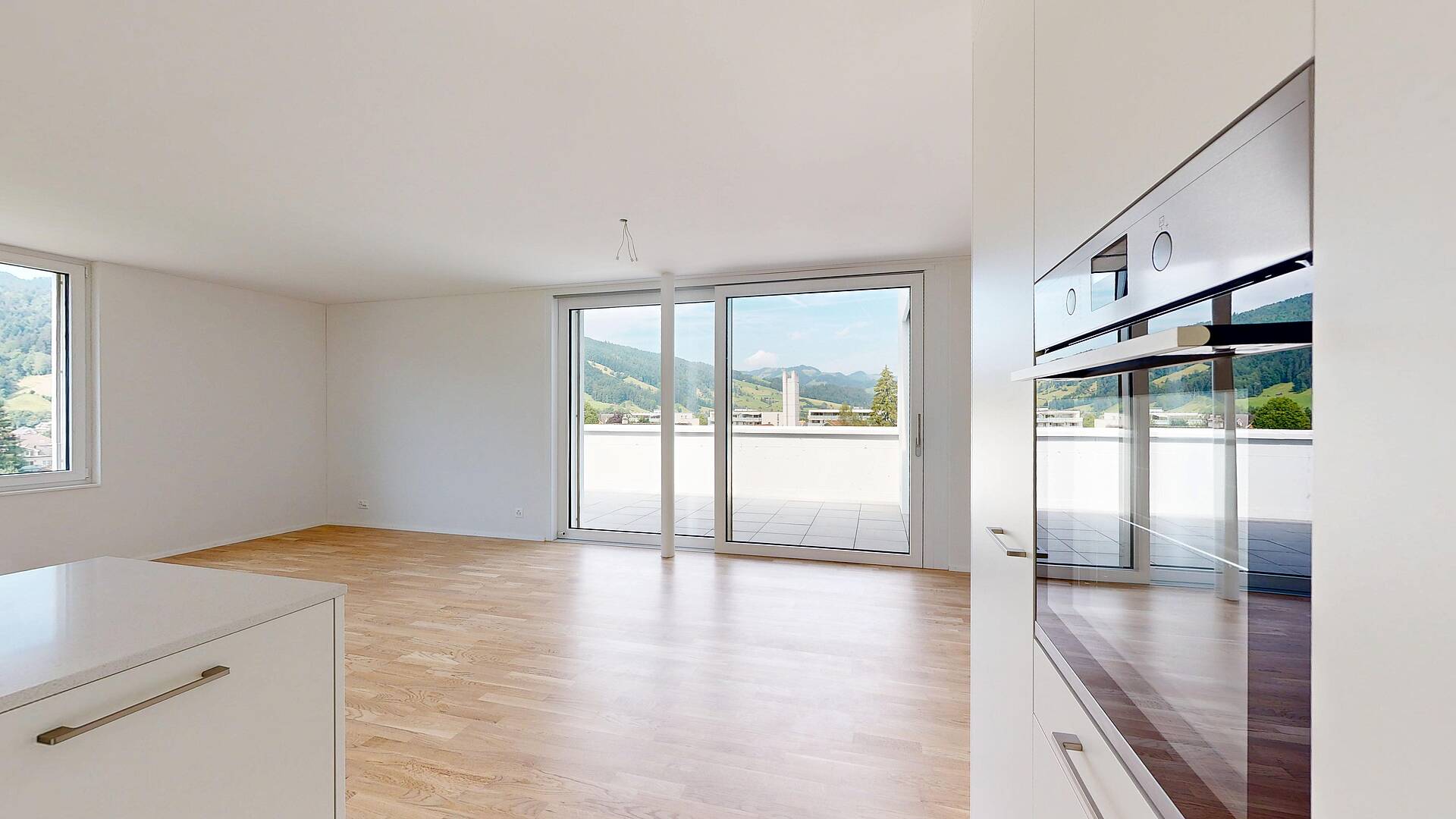 Heller, leerer Wohnraum mit Balkon und Bergblick