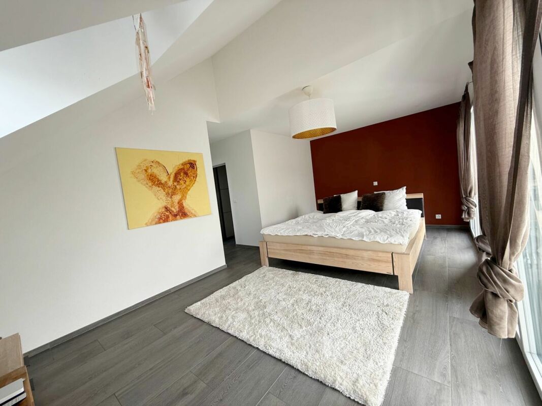 Modernes Schlafzimmer mit großem Bett und bodentiefen Fenstern
