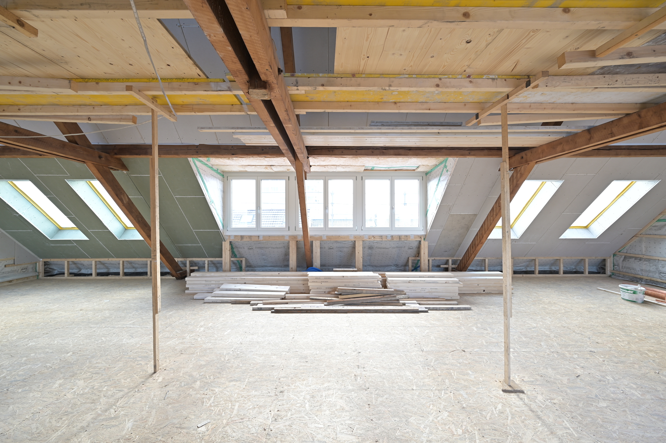 Dachgeschoss im Ausbau mit sichtbarer Holzkonstruktion