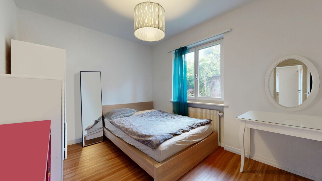 Schlafzimmer mit Fenster und Schminktisch
