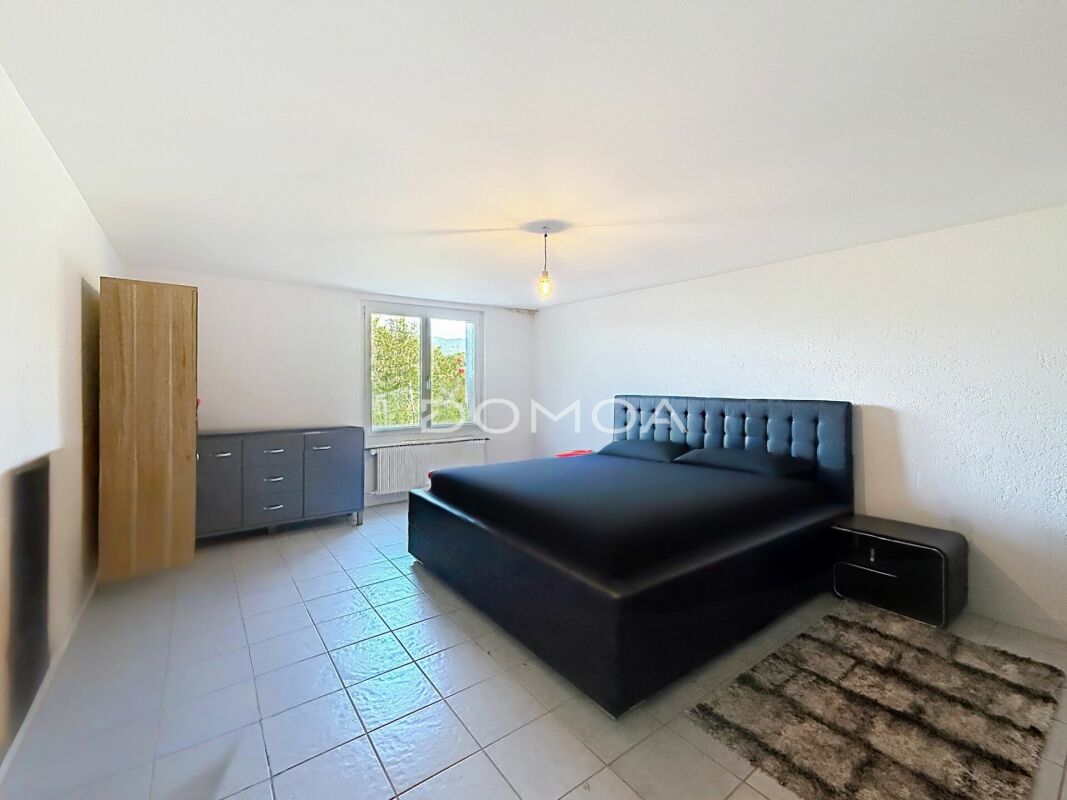 Schlichtes Schlafzimmer mit dunklem Bett
