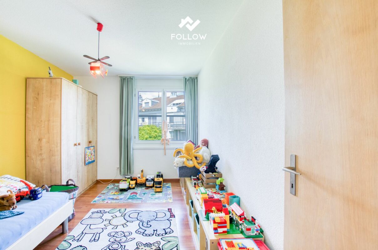 Kinderzimmer mit Spielzeug und Kleiderschrank