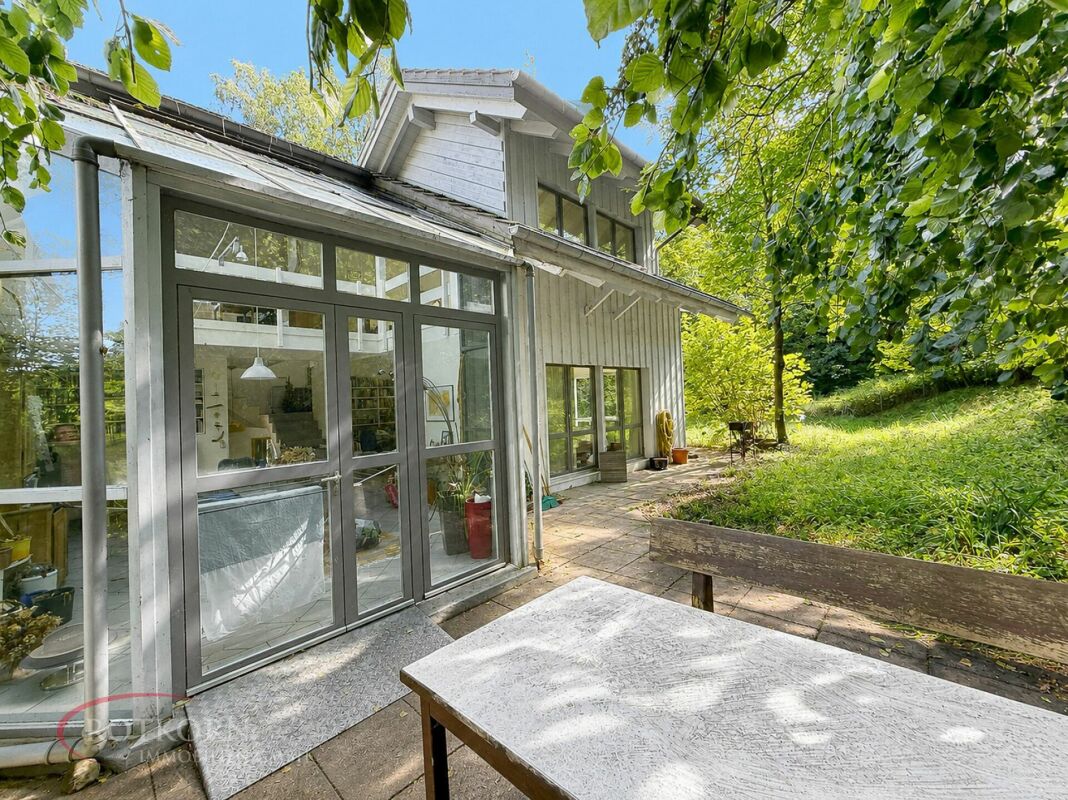 Gartenansicht eines Hauses mit verglastem Anbau