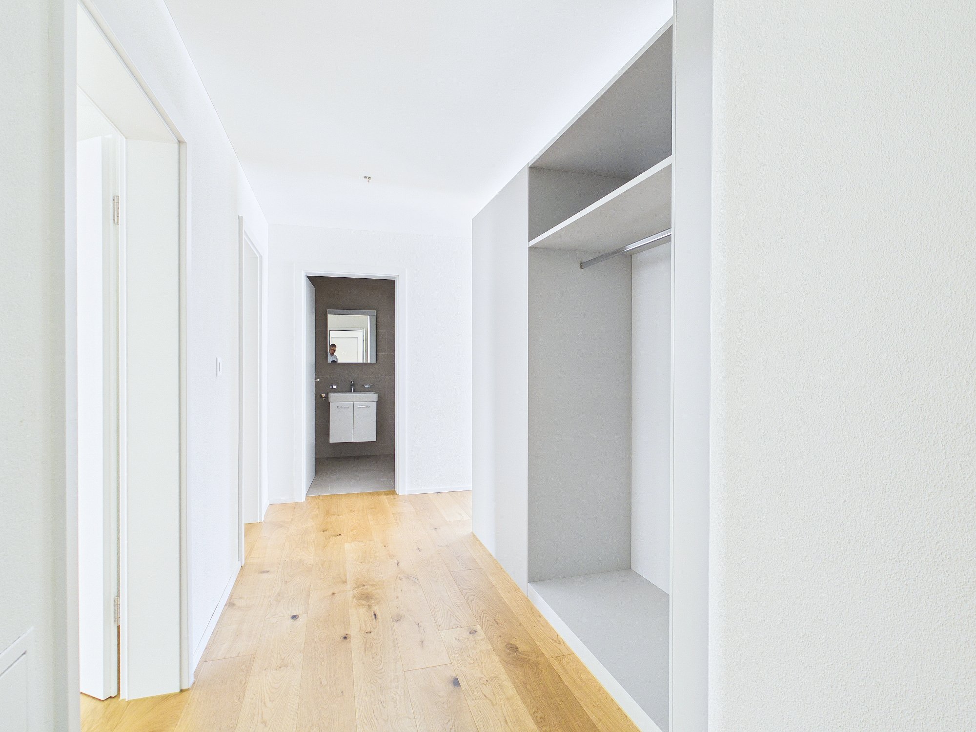 Heller Flur mit begehbarem Einbauschrank und angrenzendem Bad