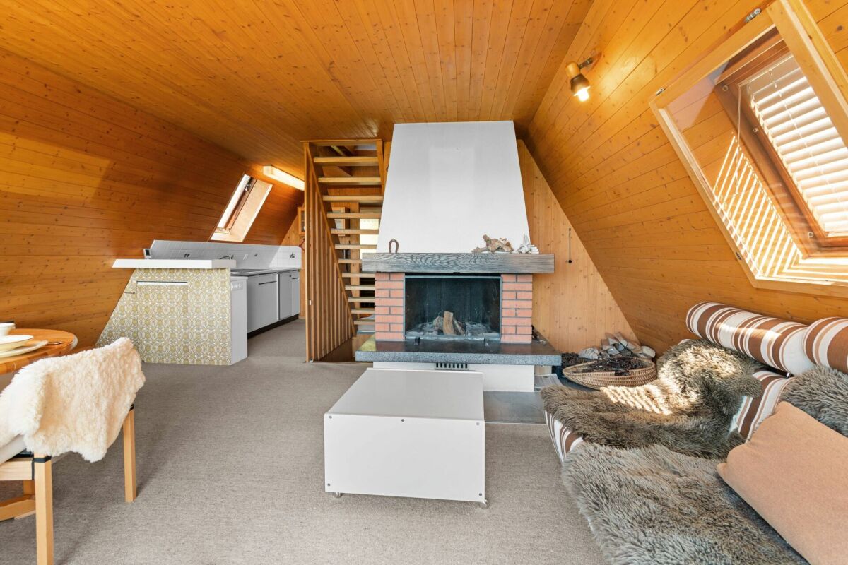Gemütlicher Dachgeschoss-Wohnraum mit Kamin und Sitzbereich