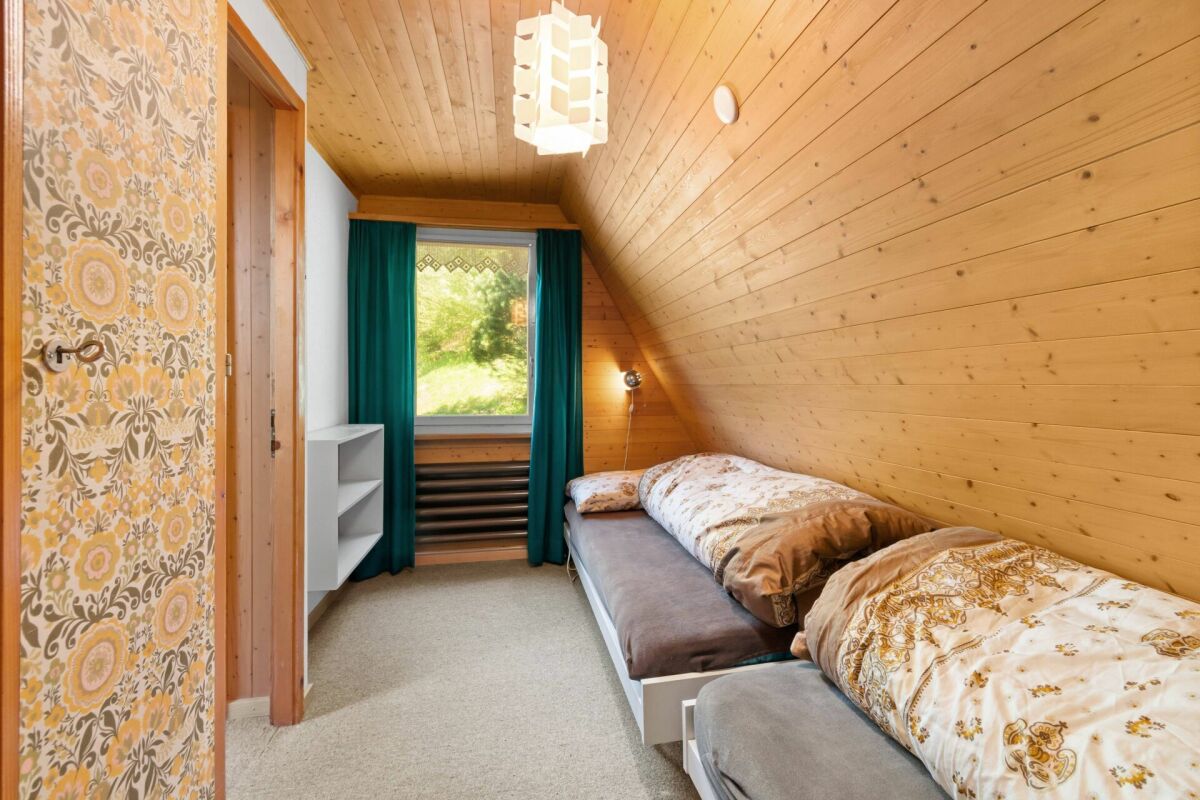 Gemütliches Dachgeschoss-Schlafzimmer mit Holzverkleidung