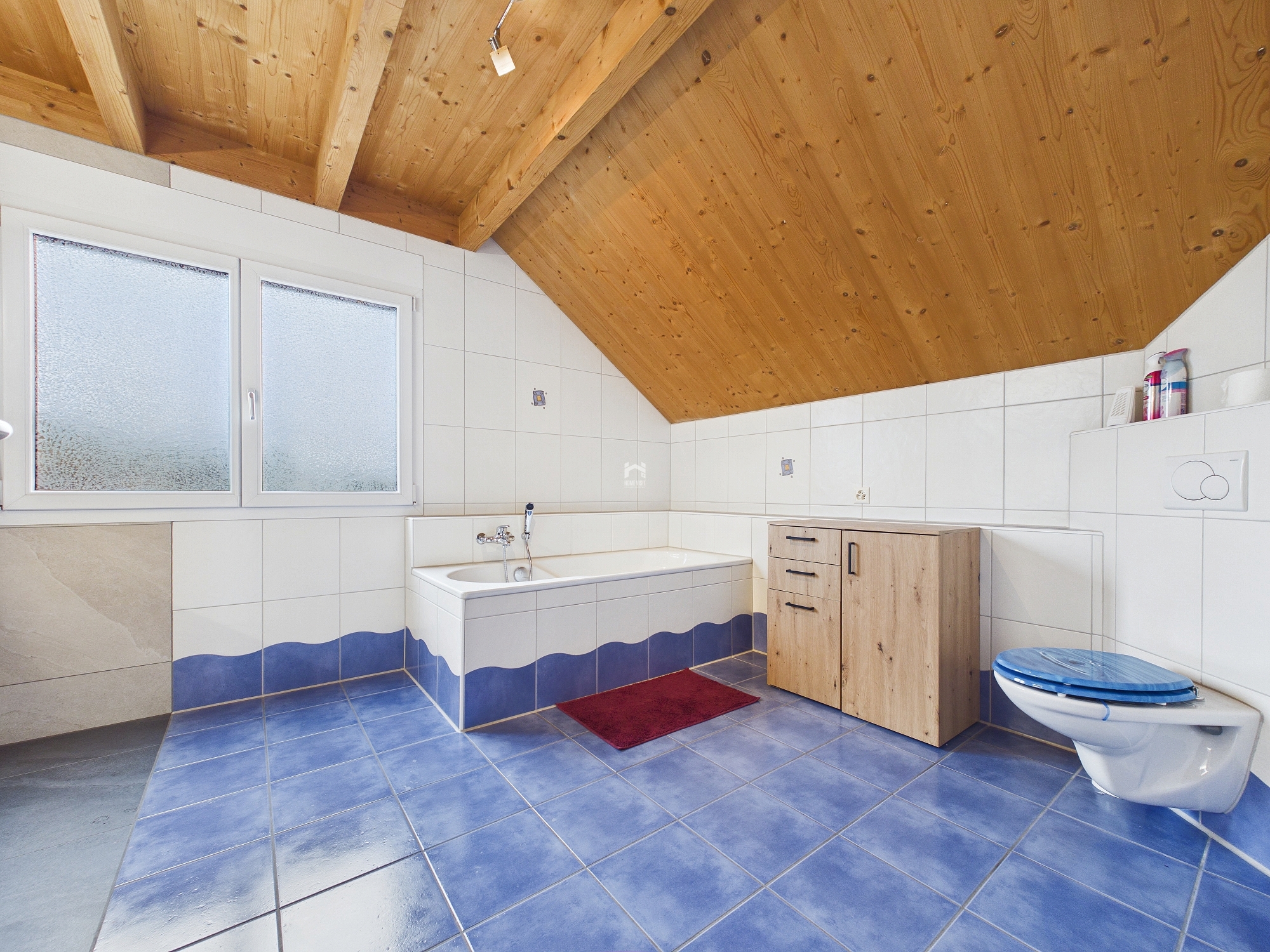 Badezimmer mit Dachschräge und Holzdecke