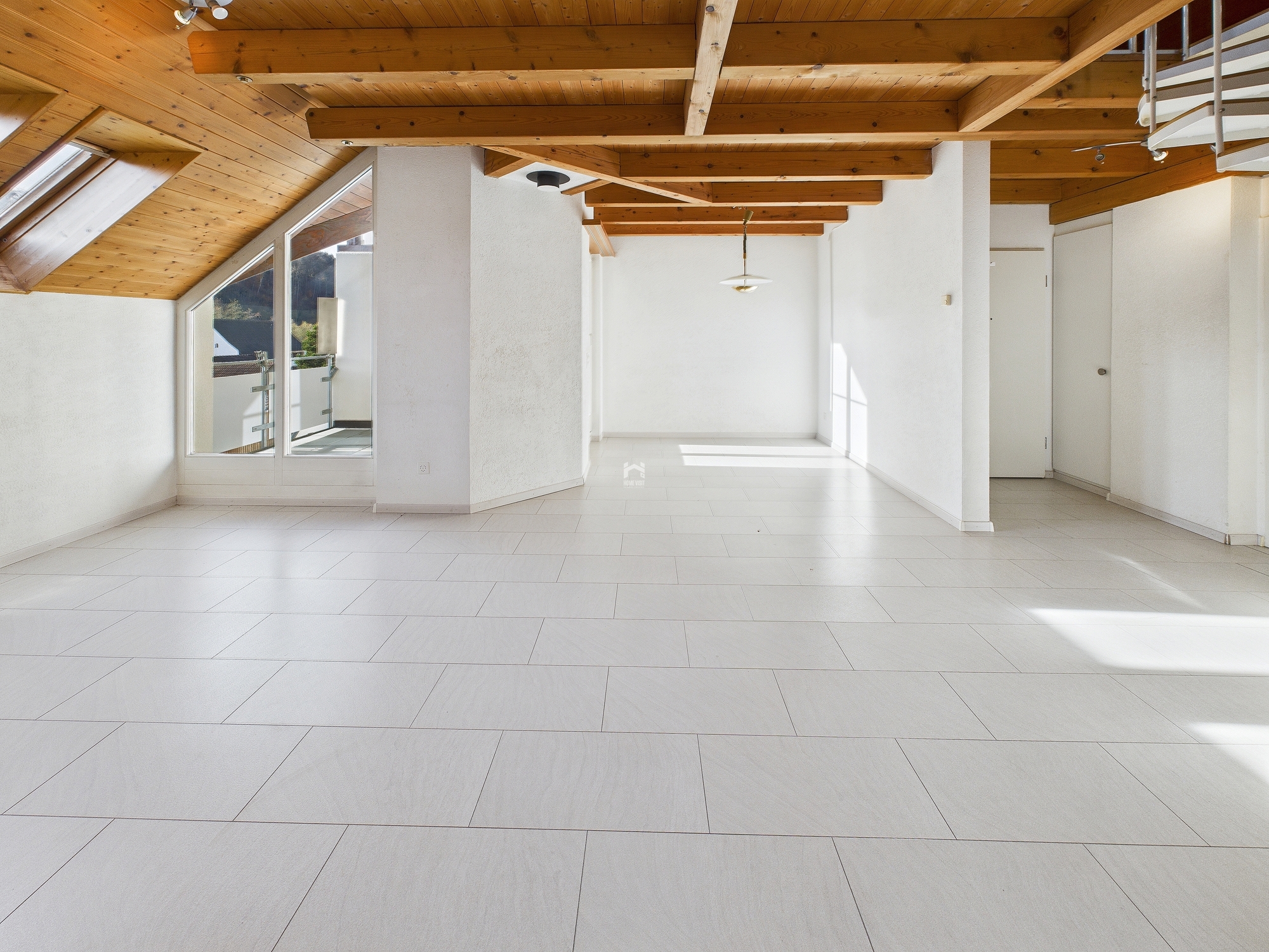 Heller Dachgeschossraum mit sichtbaren Holzbalken
