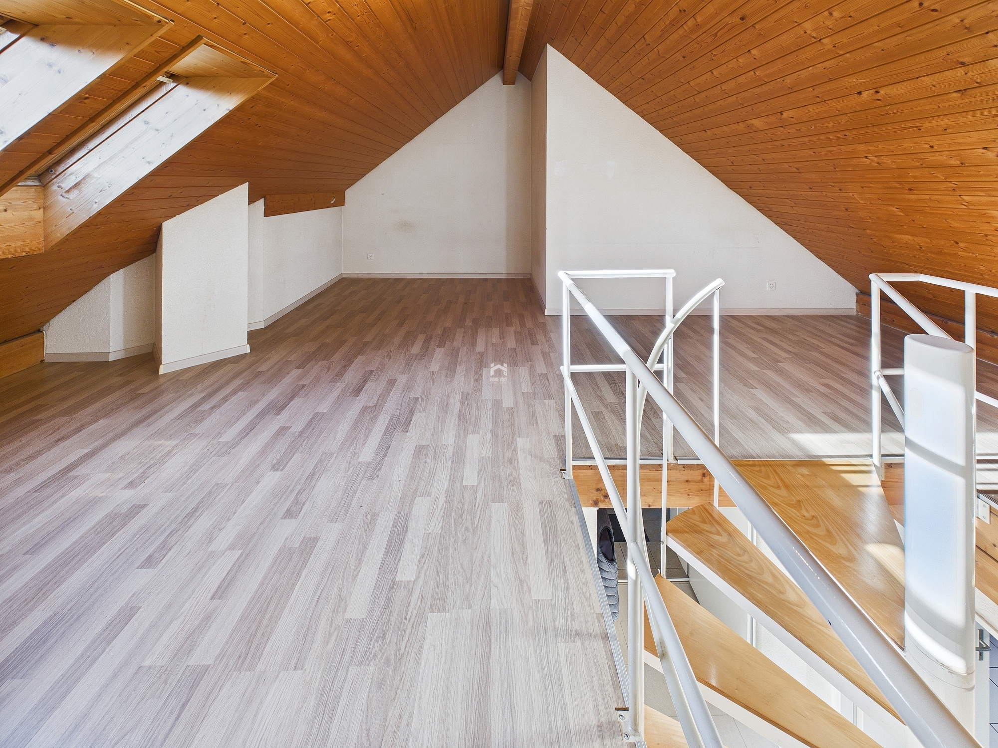 Heller Dachboden mit Holzdecke und Treppe