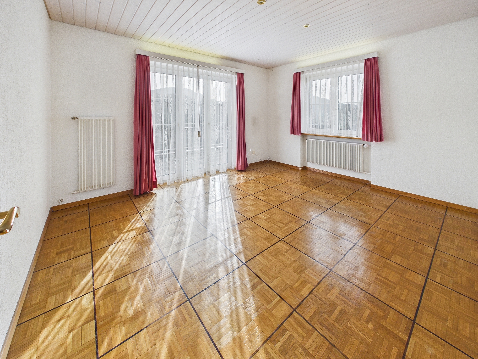Leerer heller Wohnraum mit Balkon- oder Terrassentüren