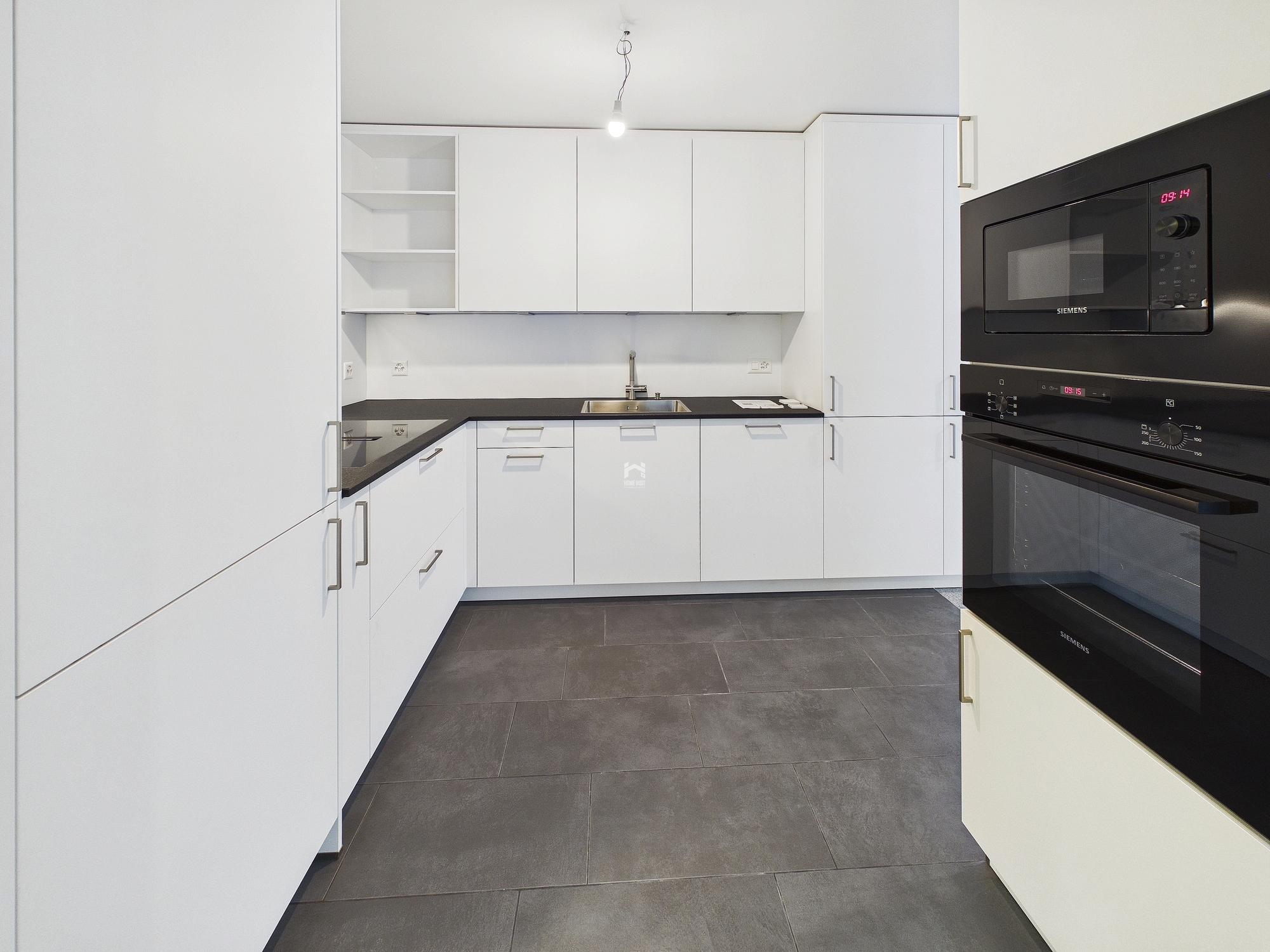 Moderne weiße Küche mit schwarzen Arbeitsflächen