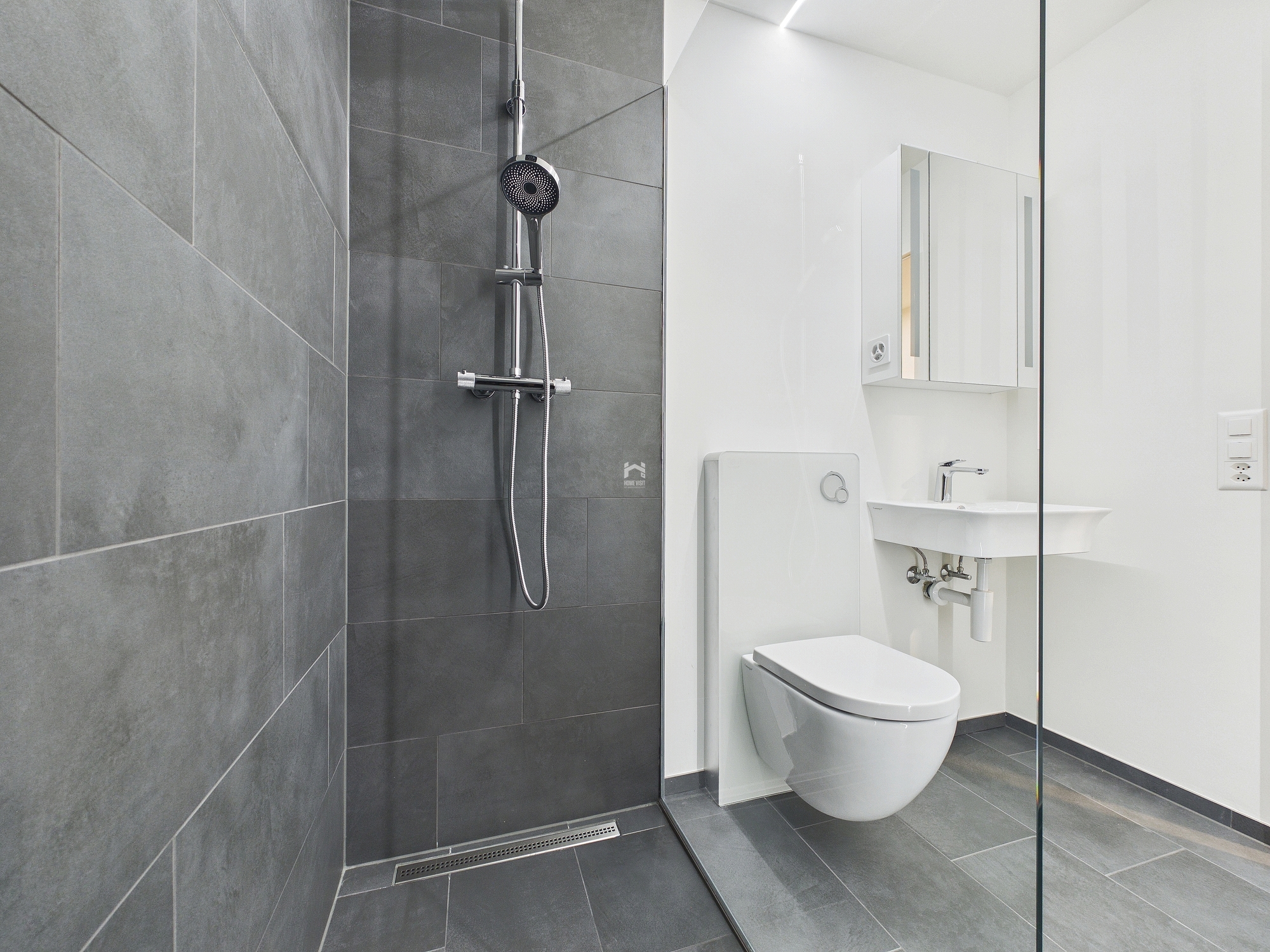 Modernes Badezimmer mit Dusche und wandhängendem WC