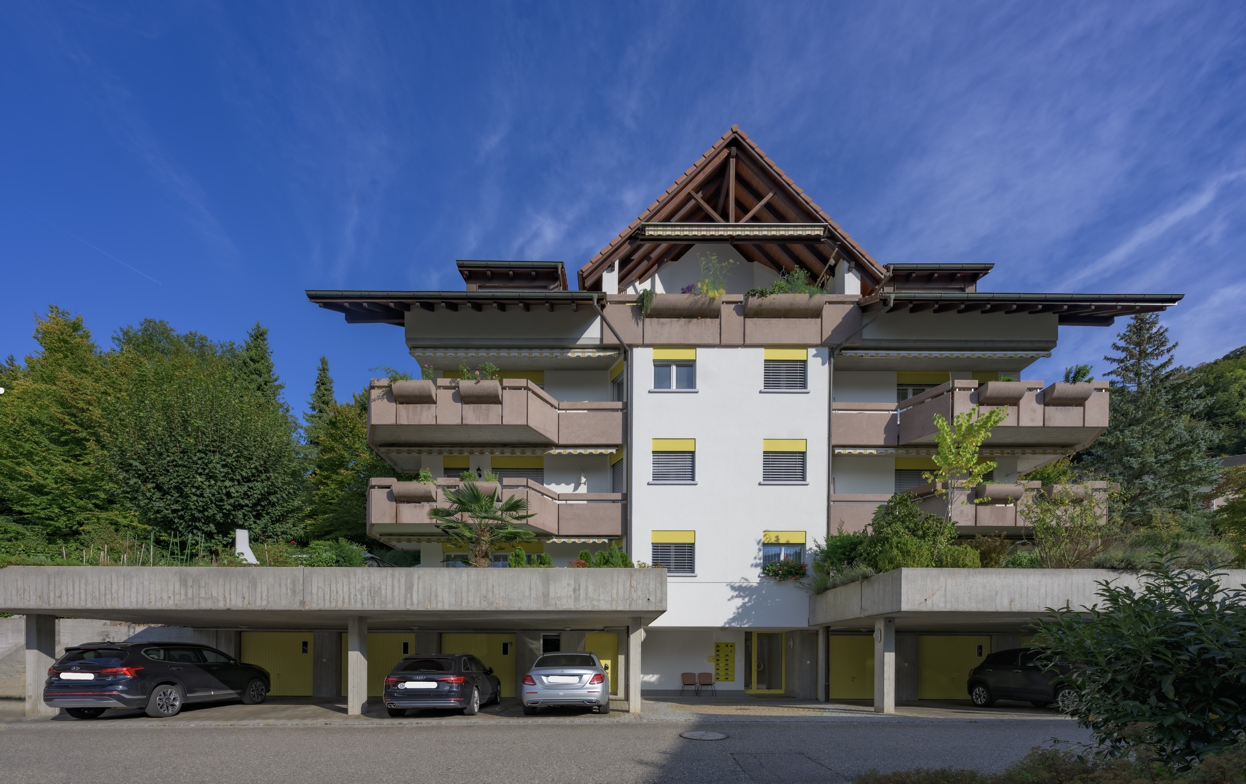 Mehrfamilienhaus mit Chaletschiefer und Balkonen
