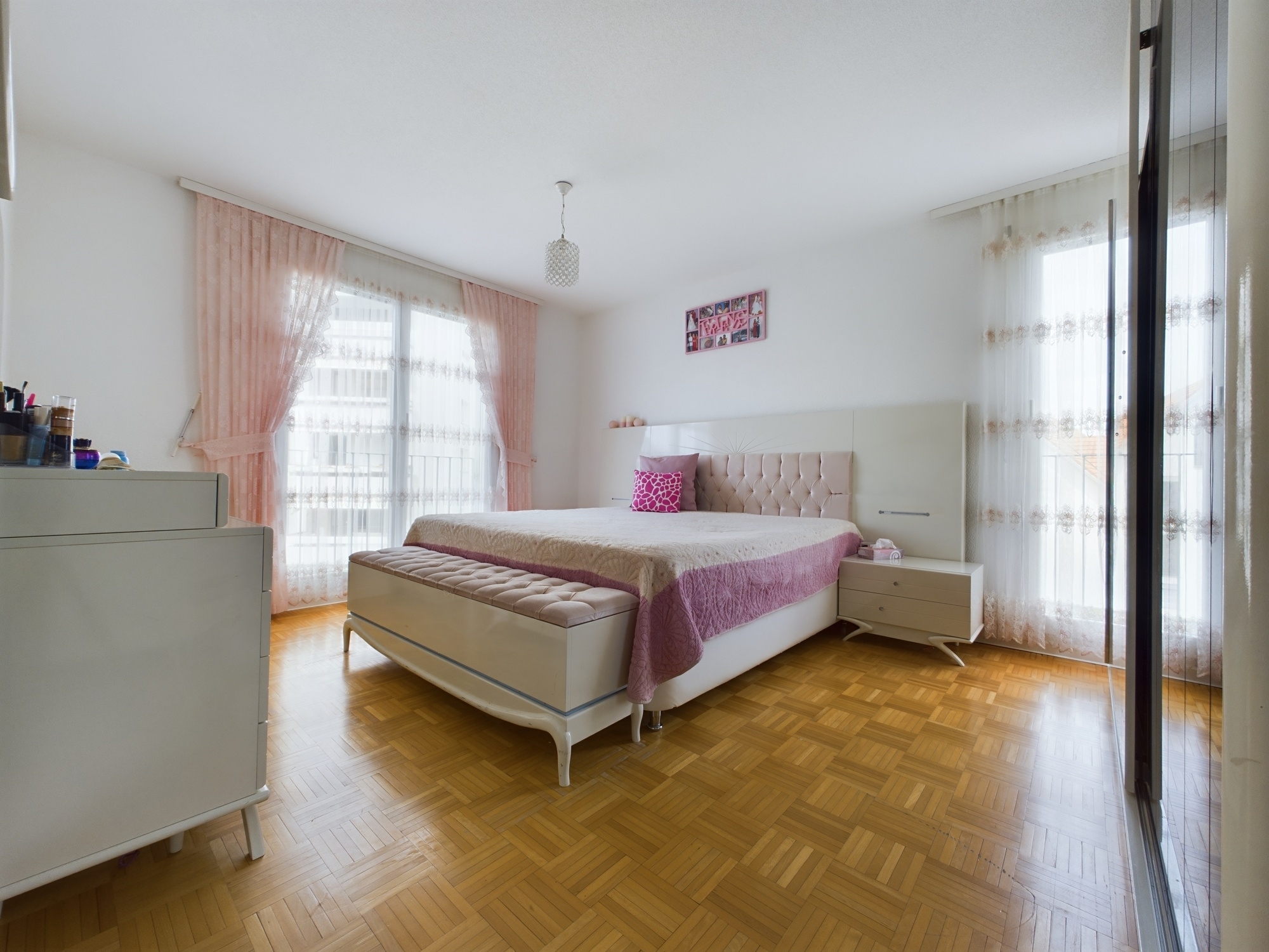 Helles Schlafzimmer mit rosafarbenen Vorhängen
