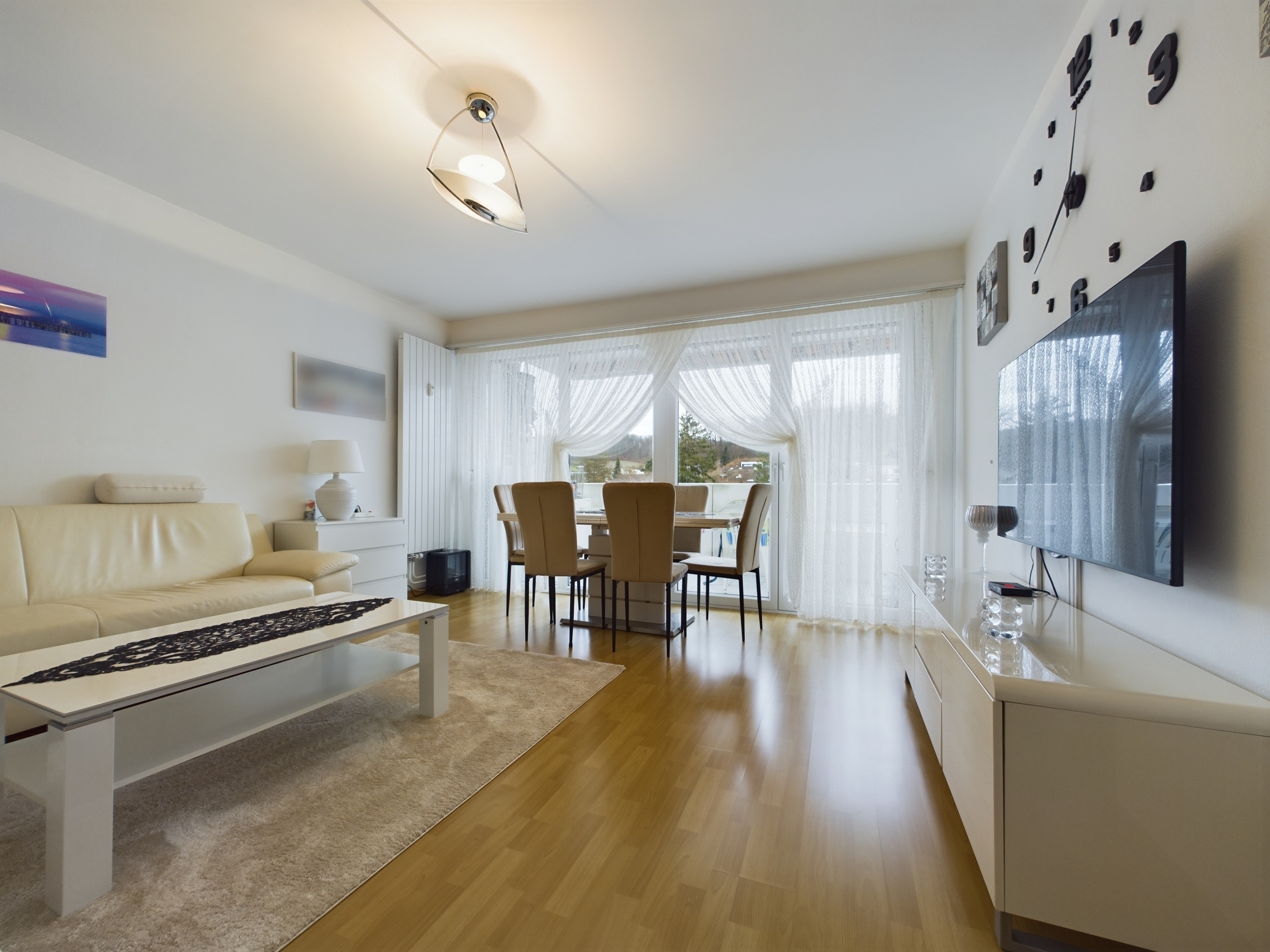 Helles Wohn- und Esszimmer mit Balkonblick