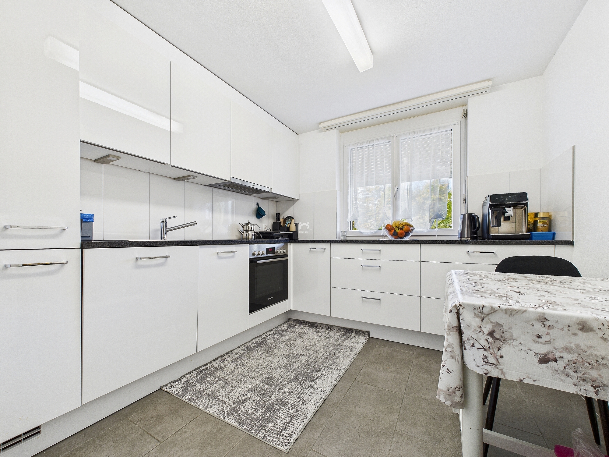 Moderne weiße Küche mit Essplatz