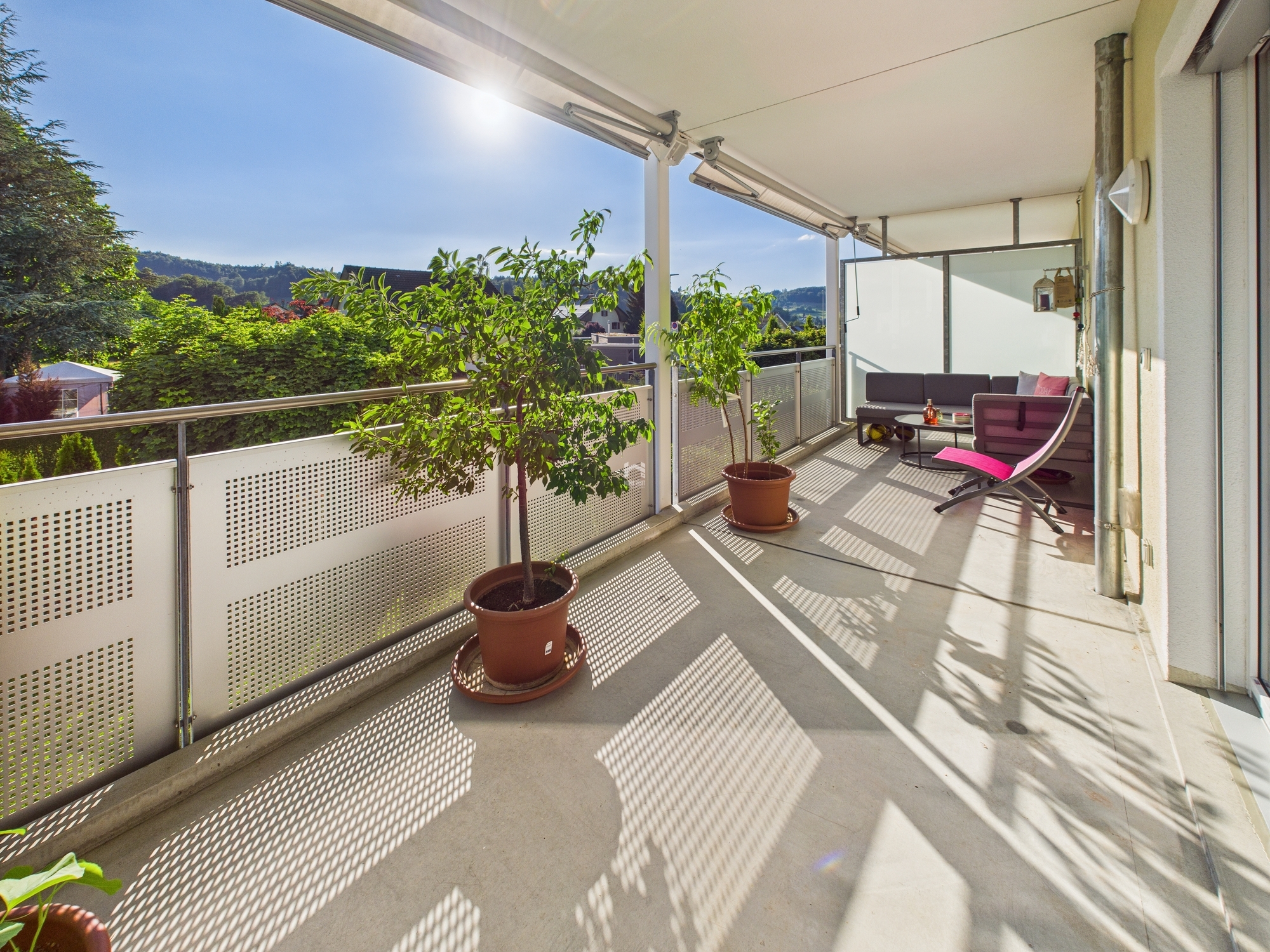 Heller Balkon mit Sitzgruppe und Pflanzen