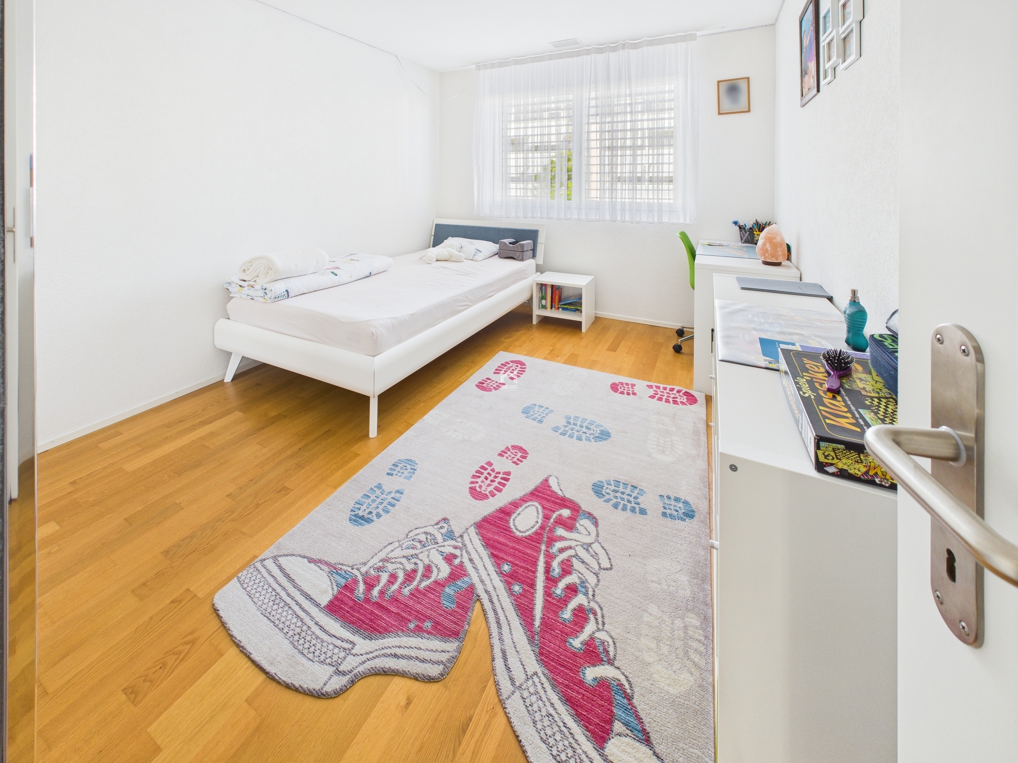 Helles Kinderzimmer mit Einzelbett und Schreibtisch