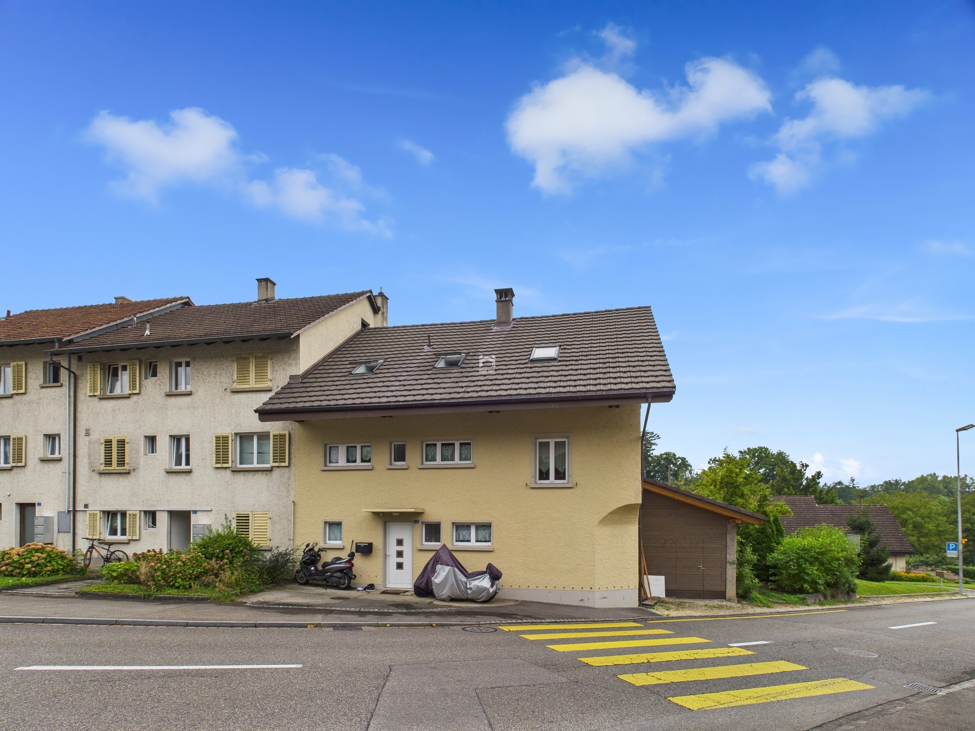Wohnhausstraße mit Mehrfamilienhaus und Anbau