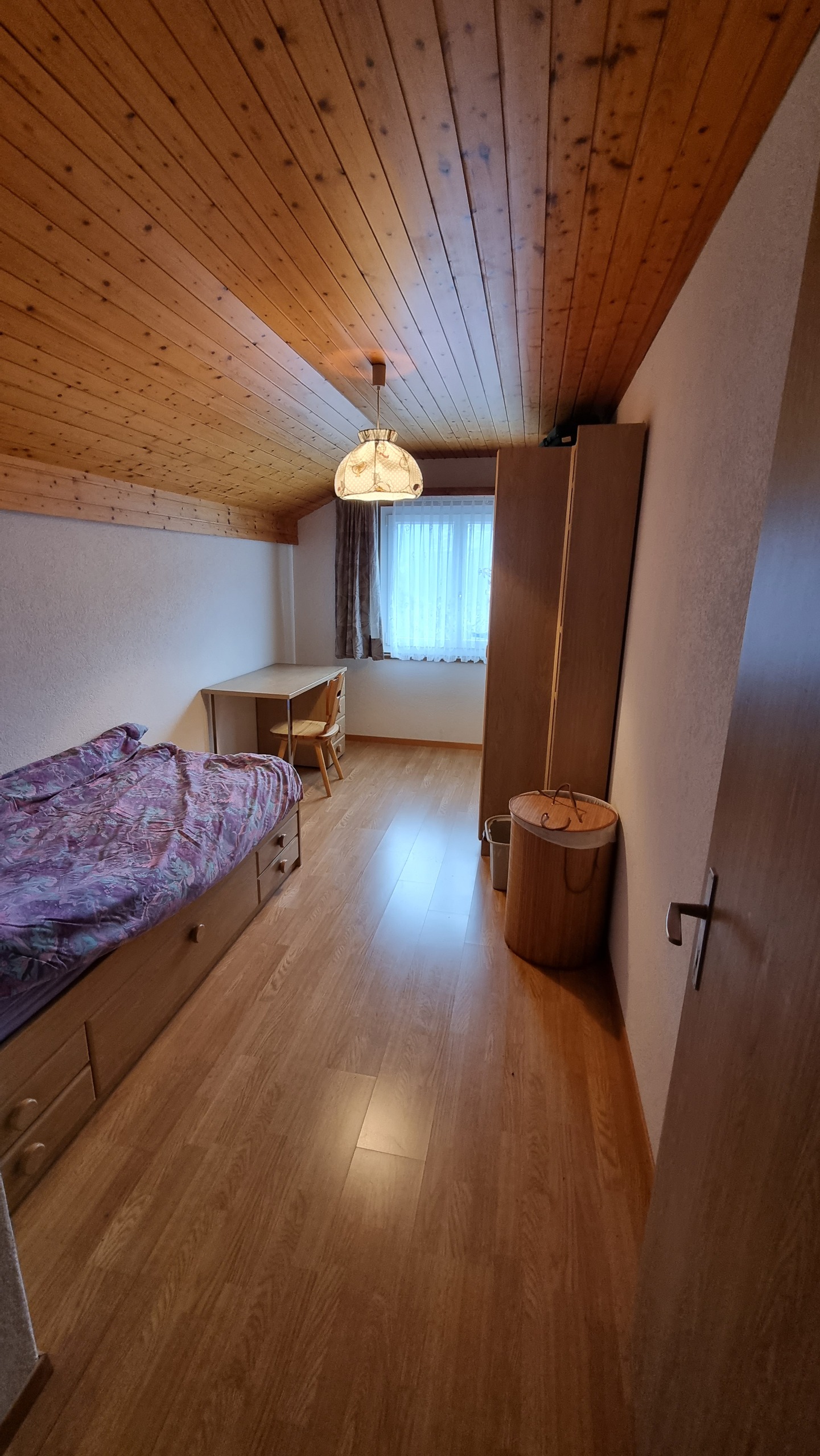 Schmales Schlafzimmer mit Holzdecke