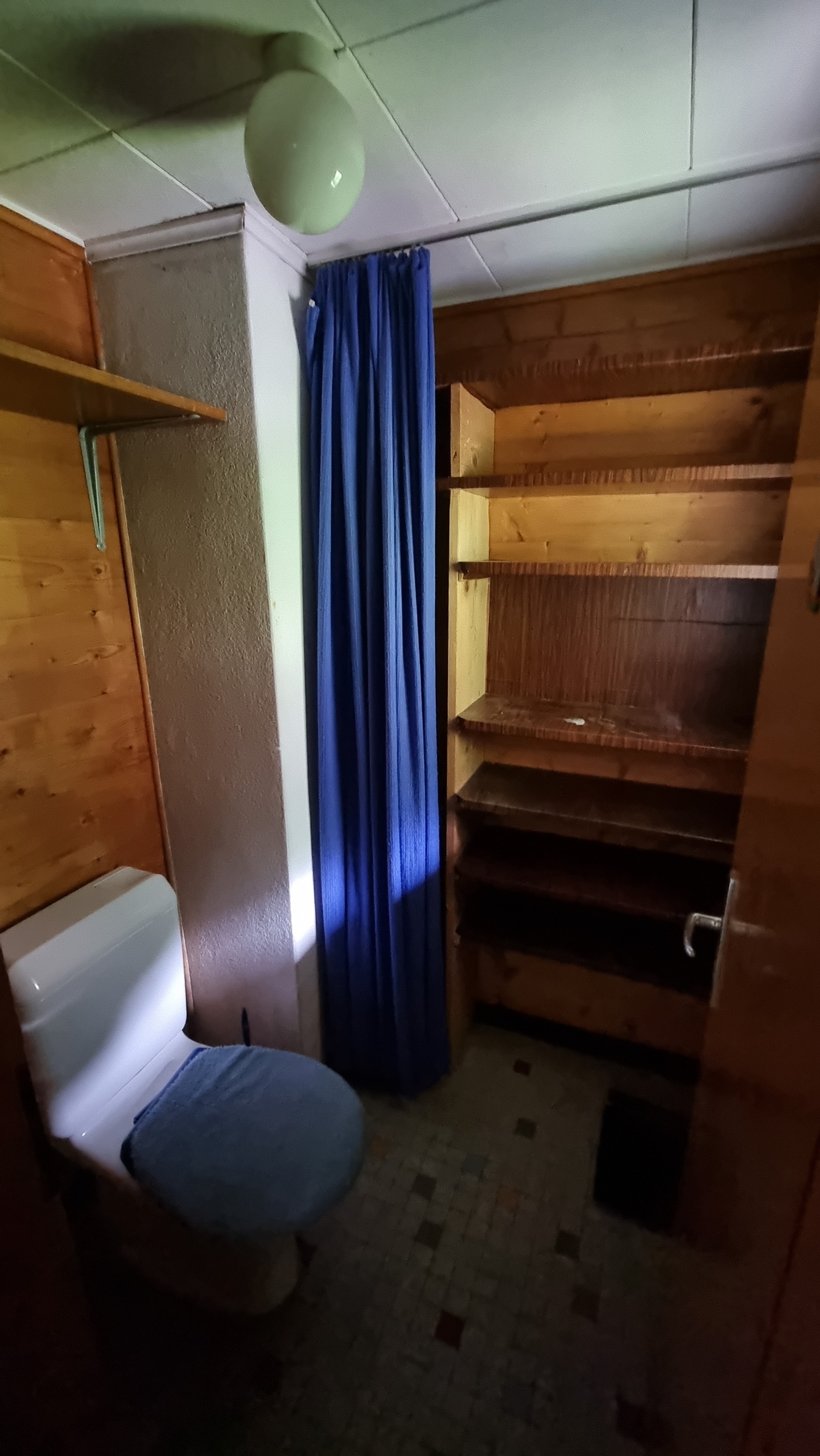 Kleines, dunkles Badezimmer mit Holzverkleidung